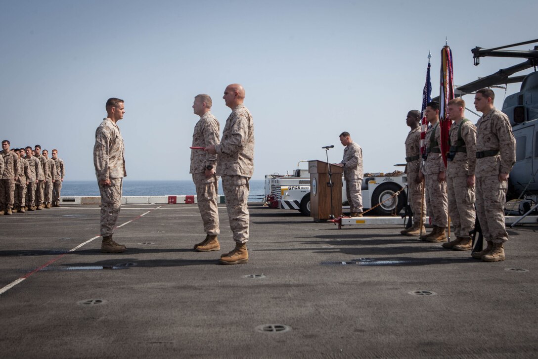 Major Matthew Peterson, operations officer, Battalion Landing Team 3/5, 15th Marine Expeditionary Unit, reports to Lt. Col. Christeon Griffin, his battalion commander, during a Bronze Star award ceremony, aboard USS Green Bay, March 3. Peterson received the award for his extraordinary guidance, zealous initiative and total dedication to duty while securing the historically violent and enemy controlled urban area of Wishtan and the surrounding region. The 15th MEU is deployed as part of the Peleliu Amphibious Ready Group as a U.S. Central Command theatre reserve force, providing support for maritime security operations and theatre security cooperation efforts in the U.S. 5th Fleet area of responsibility. (U.S. Marine Corps photo by Cpl. Bobby J. Gonzalez/Released)