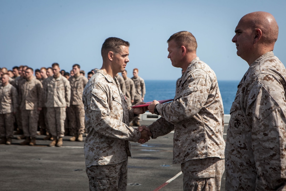 Major Matthew Peterson, operations officer,  Battalion Landing Team 3/5, 15th Marine Expeditionary Unit,  receives the citation for his Bronze Star Medal from Lt. Col. Christeon Griffith, his battalion commander, aboard USS Green Bay, March 3. Peterson received the award for his extraordinary guidance, zealous initiative and total dedication to duty while securing the historically violent and enemy controlled urban area of Wishtan and the surrounding region. The 15th MEU is deployed as part of the Peleliu Amphibious Ready Group as a U.S. Central Command theatre reserve force, providing support for maritime security operations and theatre security cooperation efforts in the U.S. 5th Fleet area of responsibility. (U.S. Marine Corps photo by Cpl. Bobby J. Gonzalez/Released)