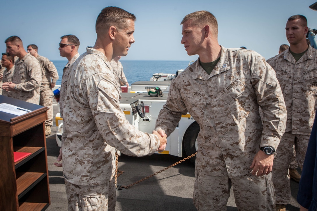 Captain Jerome Greco (right), commanding officer, Lima Company, Battalion Landing Team 3/5, 15th Marine Expeditionary Unit, congratulates Maj. Matthew Peterson, operations officer, BLT 3/5,  after his Bronze Star award ceremony aboard USS Green Bay, March 3. Peterson received the award for his extraordinary guidance, zealous initiative and total dedication to duty while securing the historically violent and enemy controlled urban area of Wishtan and the surrounding region. The 15th MEU is deployed as part of the Peleliu Amphibious Ready Group as a U.S. Central Command theatre reserve force, providing support for maritime security operations and theatre security cooperation efforts in the U.S. 5th Fleet area of responsibility. (U.S. Marine Corps photo by Cpl. Bobby J. Gonzalez/Released)