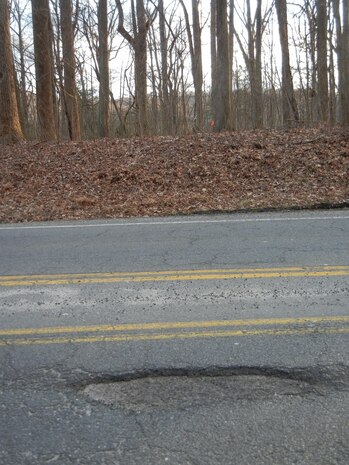 Only the top layer, or “lift,” of pavement has been peeled off of Russell Road to create this pothole near the Davis Center. 