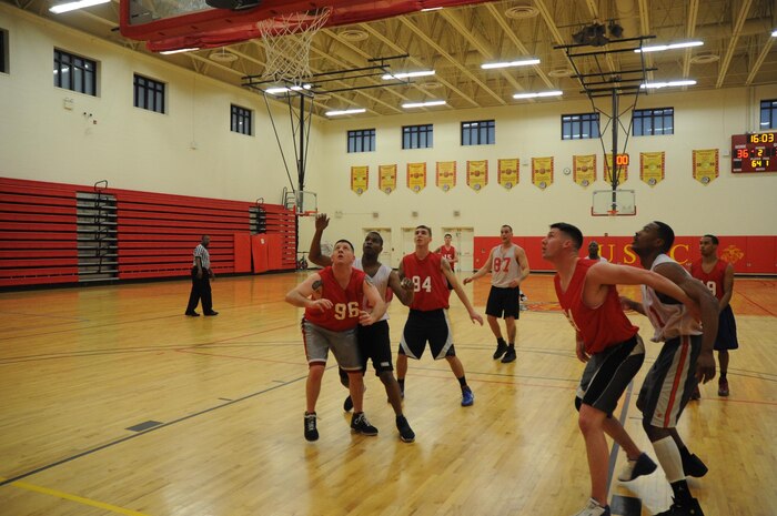 Players from TBS Ordnance and CI Weapons battle for position during an intramural basketball game at Barber Physical Activity Center on March 4. Weapons prevailed 53-52.