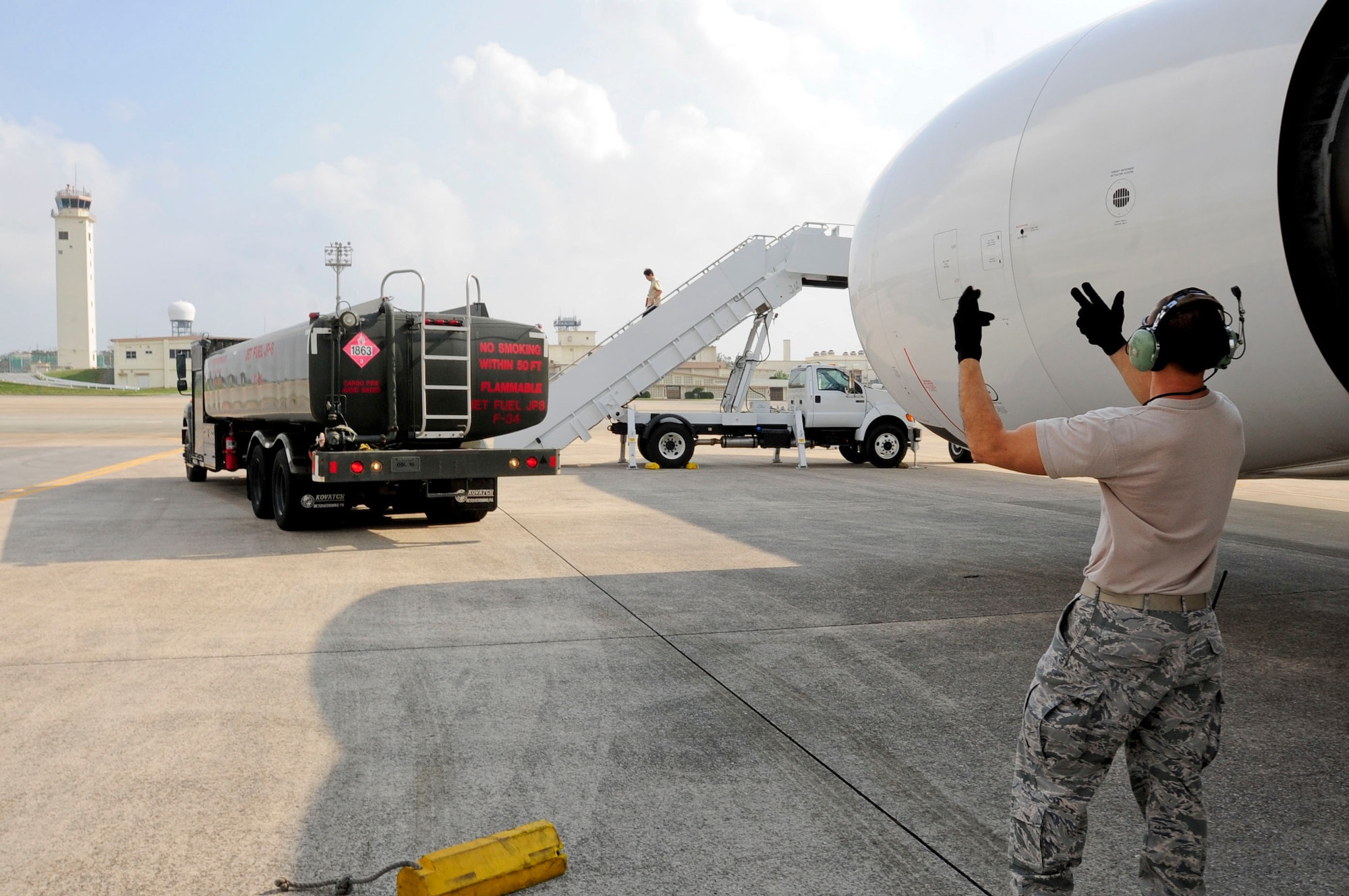 U.S. Air Force Staff Sgt. Richard Garner, 733rd Air Mobility Squadron crew chief, spots a refueling truck before providing fuel to a commercial aircraft parked on the flightline of Kadena Air Base, Japan, March 12, 2013. The 18th Wing and 733rd AMS assisted three aircraft that diverted from Naha airfield with services such as refueling. Kadena Air Base is a divert location for Naha airfield and is occasionally used when weather or other situations prevent aircraft from landing at Naha. (U.S. Air Force photo/Staff Sgt. Darnell T. Cannady)