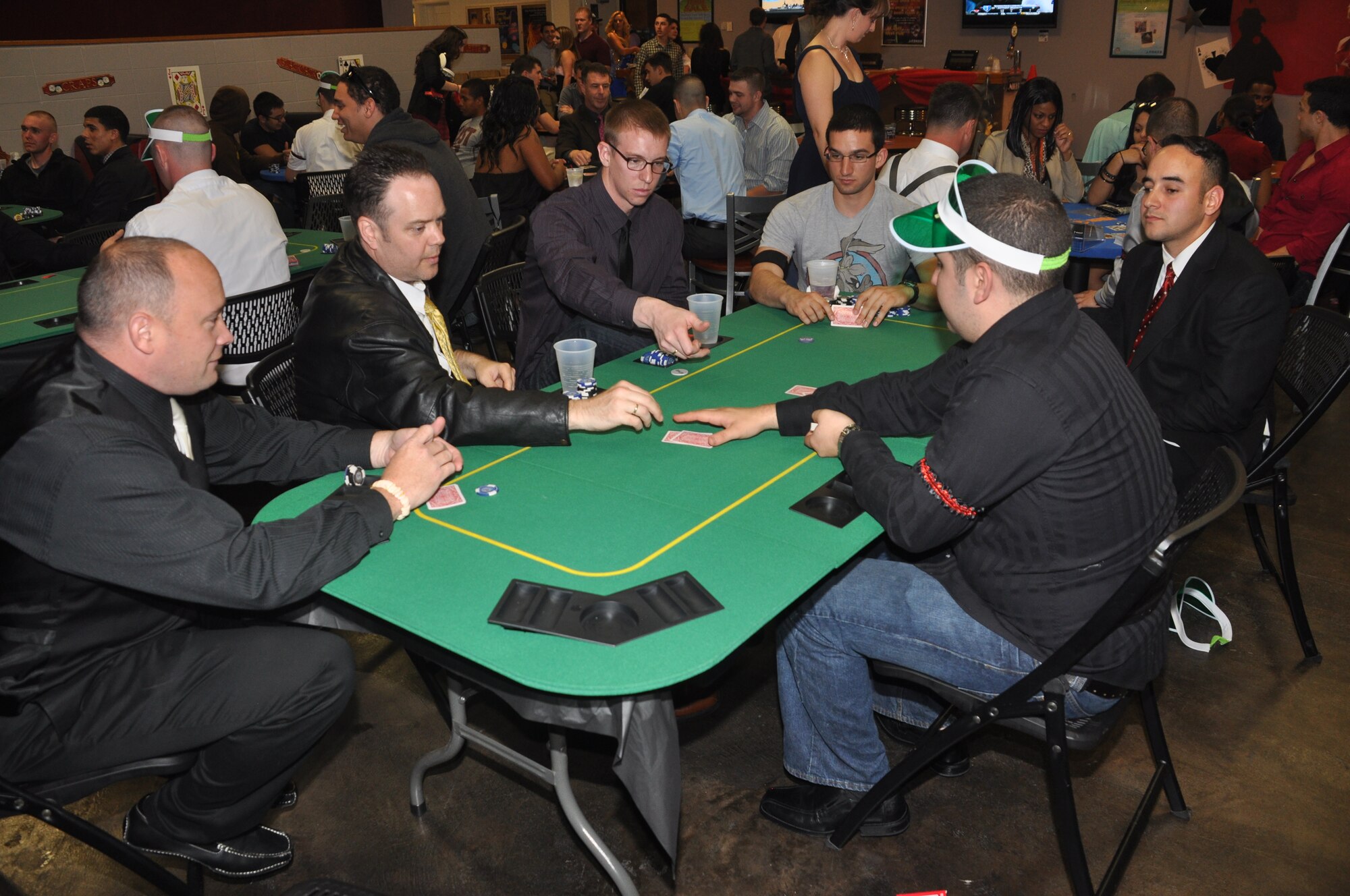 Airmen participate in a game of poker during the complimentary Casino Royale Food Drive at the Landing Zone at Hurlburt Field, Fla., March 9, 2013. Participants were able to play the card game as well as craps, roulette and blackjack. (Courtesy photo by Senior Airman Brandon Gilliatt)  
