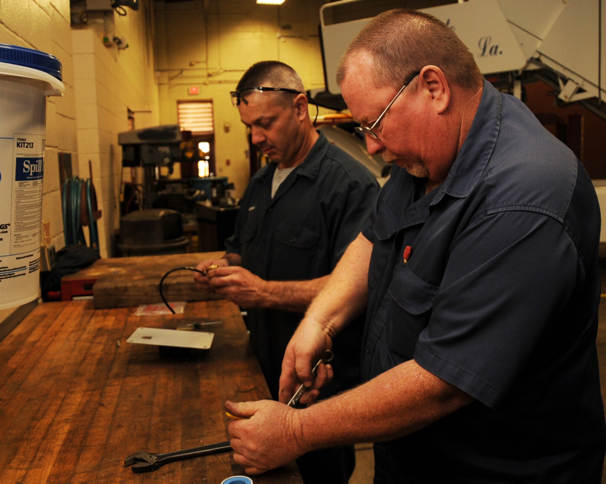 Tyler Cagnina and Bruce Freeman, 2nd Logistics Readiness Squadron heavy mobile equipment mechanics, repair an air pressure valve on Barksdale Air Force Base, La., March 12. LRS vehicle mechanics perform everything from routine oil changes to more complex maintenance to include engine rebuilds. (U.S. Air Force photo/Senior Airman Sean Martin)