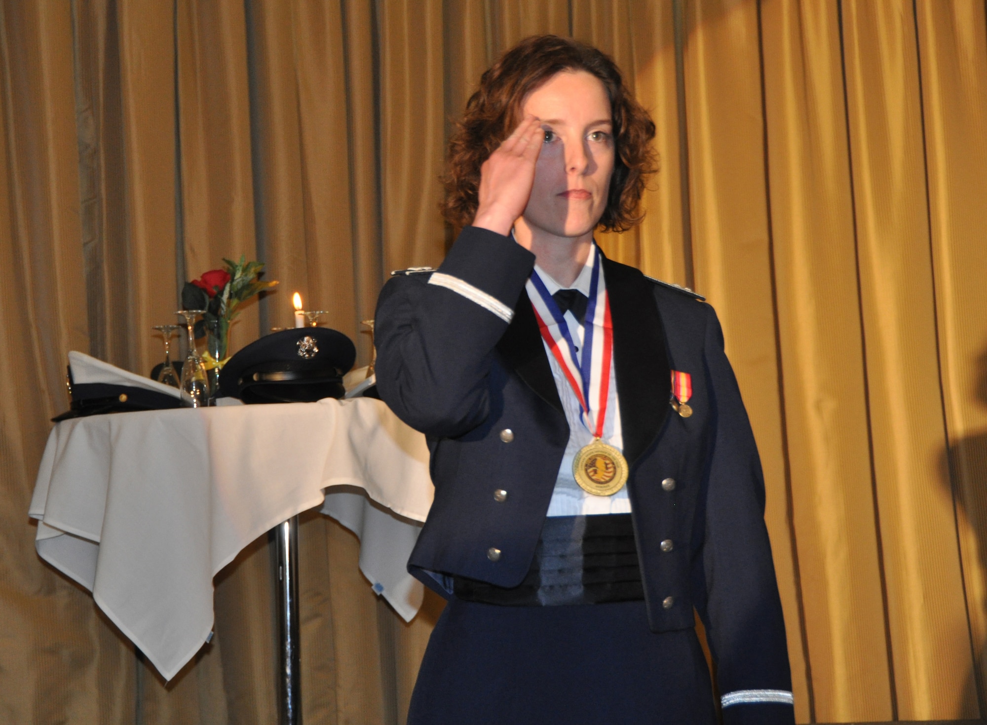 JOINT BASE MCGUIRE-DIX-LAKEHURST, N.J. - Capt. Margaret Chandler of the 514th Aerospace Medicine Squadron salutes the audience during the award nominee's  procession into the banquet room at the annual awards banquet held March 9 here. The captain was one of nine Reserve officer nominees for the  Company Grade Officer of the Year 2012 for the 514th Air Mobility Wing. (U.S. Air Force photo/MAster Sgt. Donna T. Jeffries)