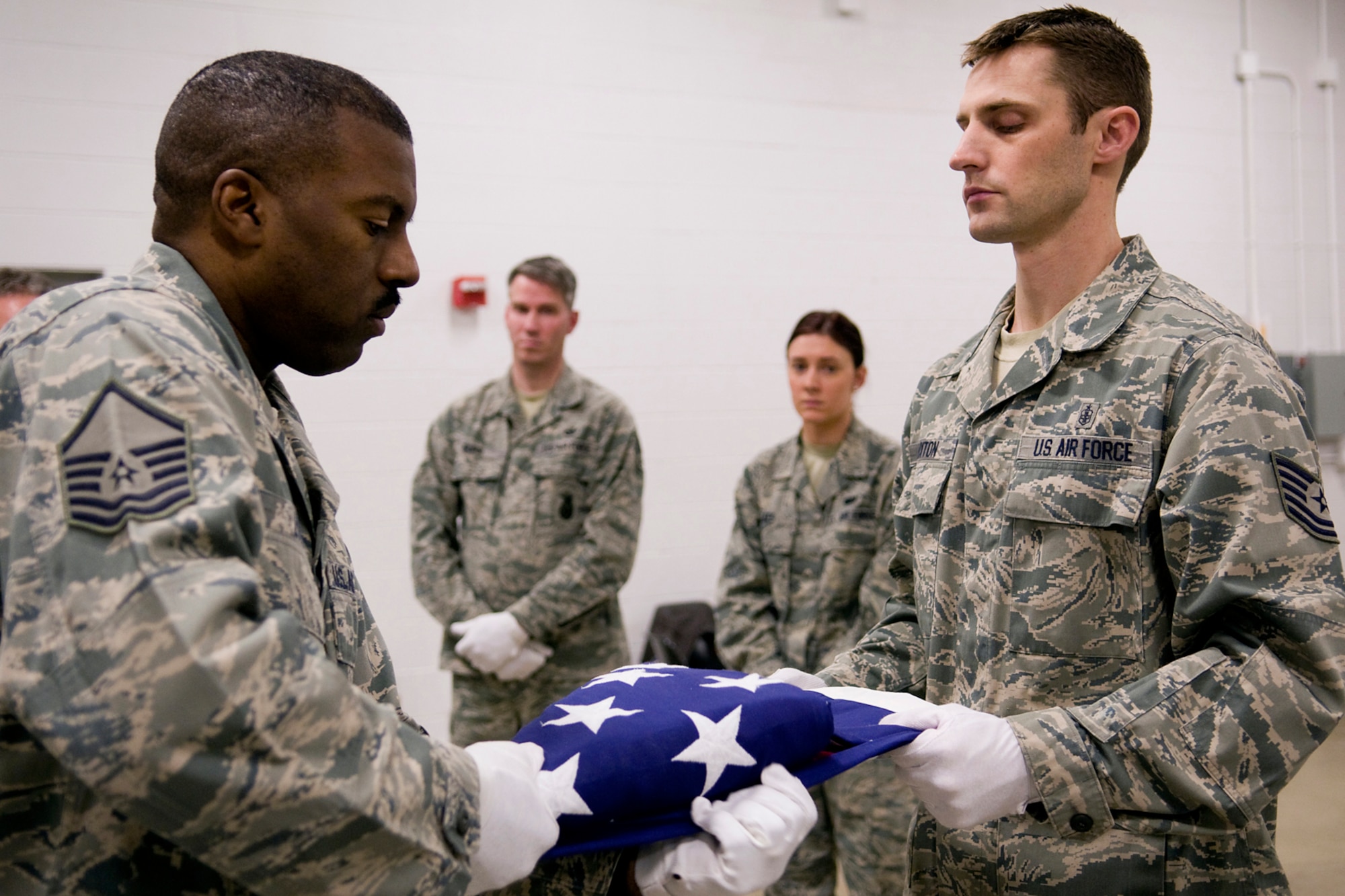 GRISSOM AIR RESERVE BASE, Ind. -- Master Sgt. Mark Lyle, left, and Tech. Sgt. Ryan Buxton demonstrate how to properly fold an American flag during honor guard training held here March 4. Both are honor guard trainers assigned to the 445th Airlift Wing, and Lyle manages the base honor guard at Wright-Patterson Air Force Base, Ohio. (U.S. Air Force photo/Tech. Sgt. Mark R. W. Orders-Woempner)
