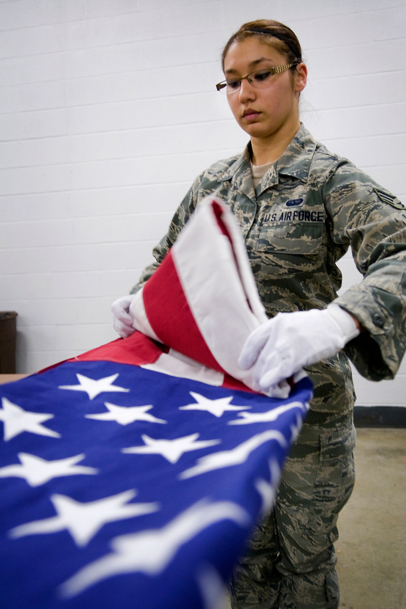 GRISSOM AIR RESERVE BASE, Ind. -- Senior Airman Angela Jones, 434th Civil Engineer Squadron information management apprentice, folds an American flag during honor guard training held here March 4. Jones, along with 11 other Airmen, recently completed the week-long training course, which included instruction on honor guard facing movements, flag folding, casket bearing and weapons. (U.S. Air Force photo/Tech. Sgt. Mark R. W. Orders-Woempner)
