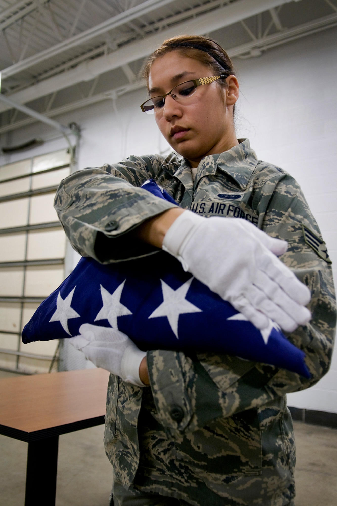 GRISSOM AIR RESERVE BASE, Ind. -- Senior Airman Angela Jones, 434th Civil Engineer Squadron information management apprentice, performs a full dress of an American flag during honor guard training held here March 4. Jones, along with 11 other Airmen, recently completed the week-long training course, which included instruction on honor guard facing movements, flag folding, casket bearing and weapons. (U.S. Air Force photo/Tech. Sgt. Mark R. W. Orders-Woempner)
