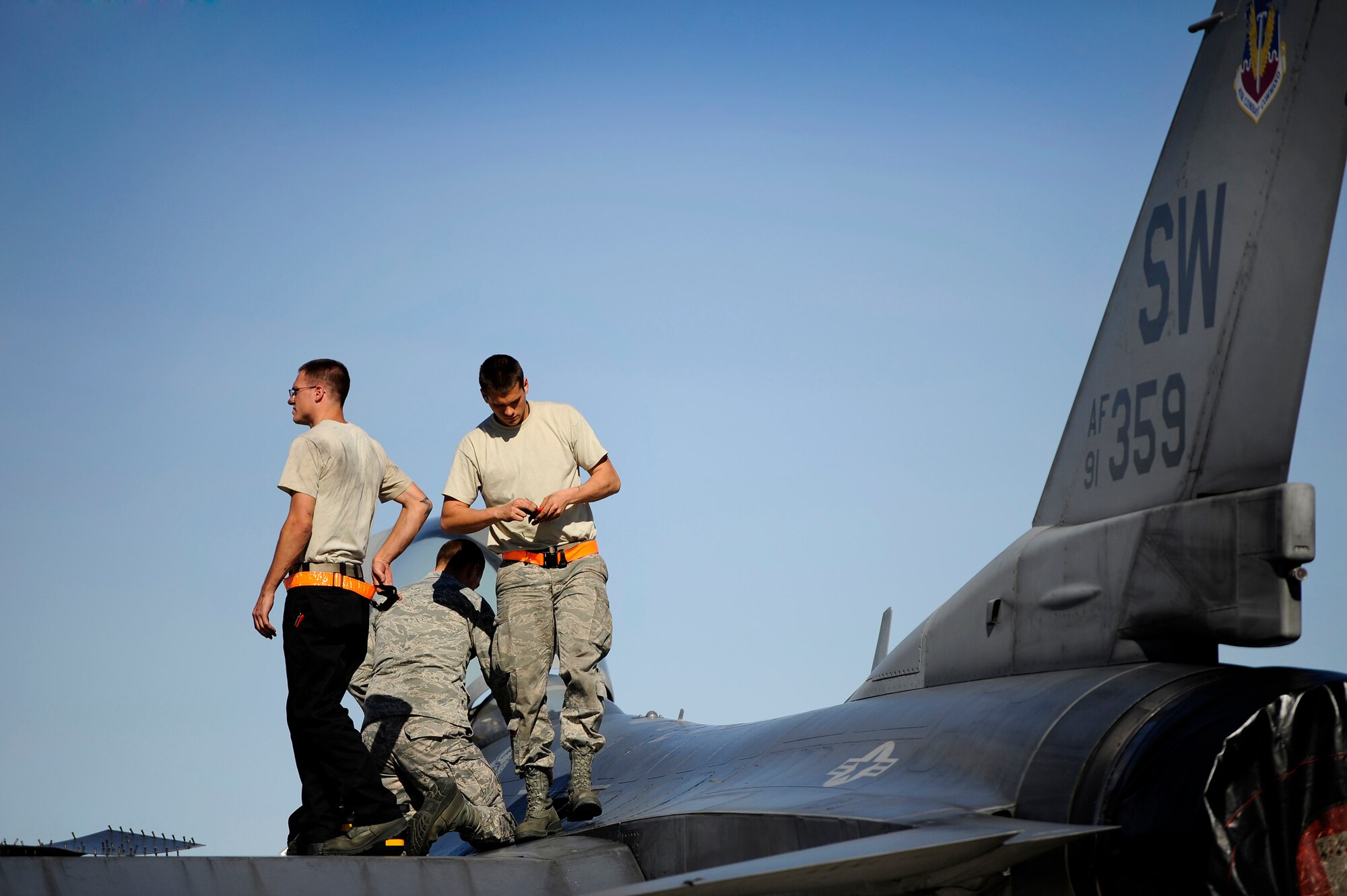 U.S. Air Force crew chiefs assigned to the 20th Aircraft Maintenance Squadron move along the top of an F-16 Fighting Falcon to perform maintenance on the aircraft during Red Flag 13-3, March 11, 2013, Nellis Air Force Base, Nev. About 23 crew chiefs from Shaw are participating in the Red Flag exercise. They have worked around-the-clock maintaining 79th FS jets so the pilots of the squadron are able to fly and get the training they need during each day of the exercise. (U.S. Air Force photo by Staff Sgt. Kenny Holston/Released)