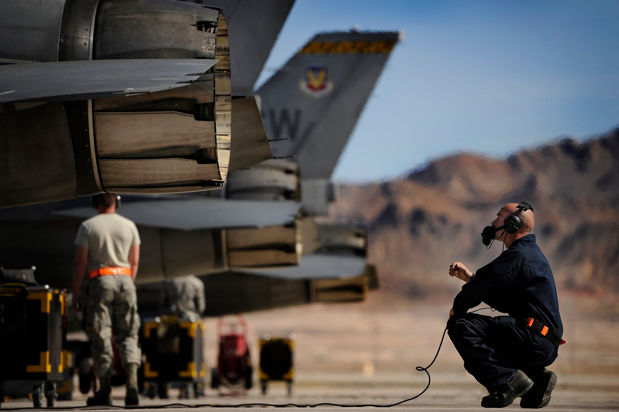 U.S. Air Force Senior Airman Cecil Lovette, 20th Aircraft Maintenance Squadron crew chief, communicates with a 79th Fighter Squadron ‘Tigers’ pilot via radio headset while going through preflight checks prior to takeoff during Red Flag 13-3, March 11, 2013, Nellis Air Force Base, Nev. About 23 crew chiefs from Shaw are participating in the Red Flag exercise. They have worked around-the-clock maintaining 79th FS jets so the pilots of the squadron are able to fly and get the training they need during each day of the exercise. (U.S. Air Force photo by Staff Sgt. Kenny Holston/Released)  