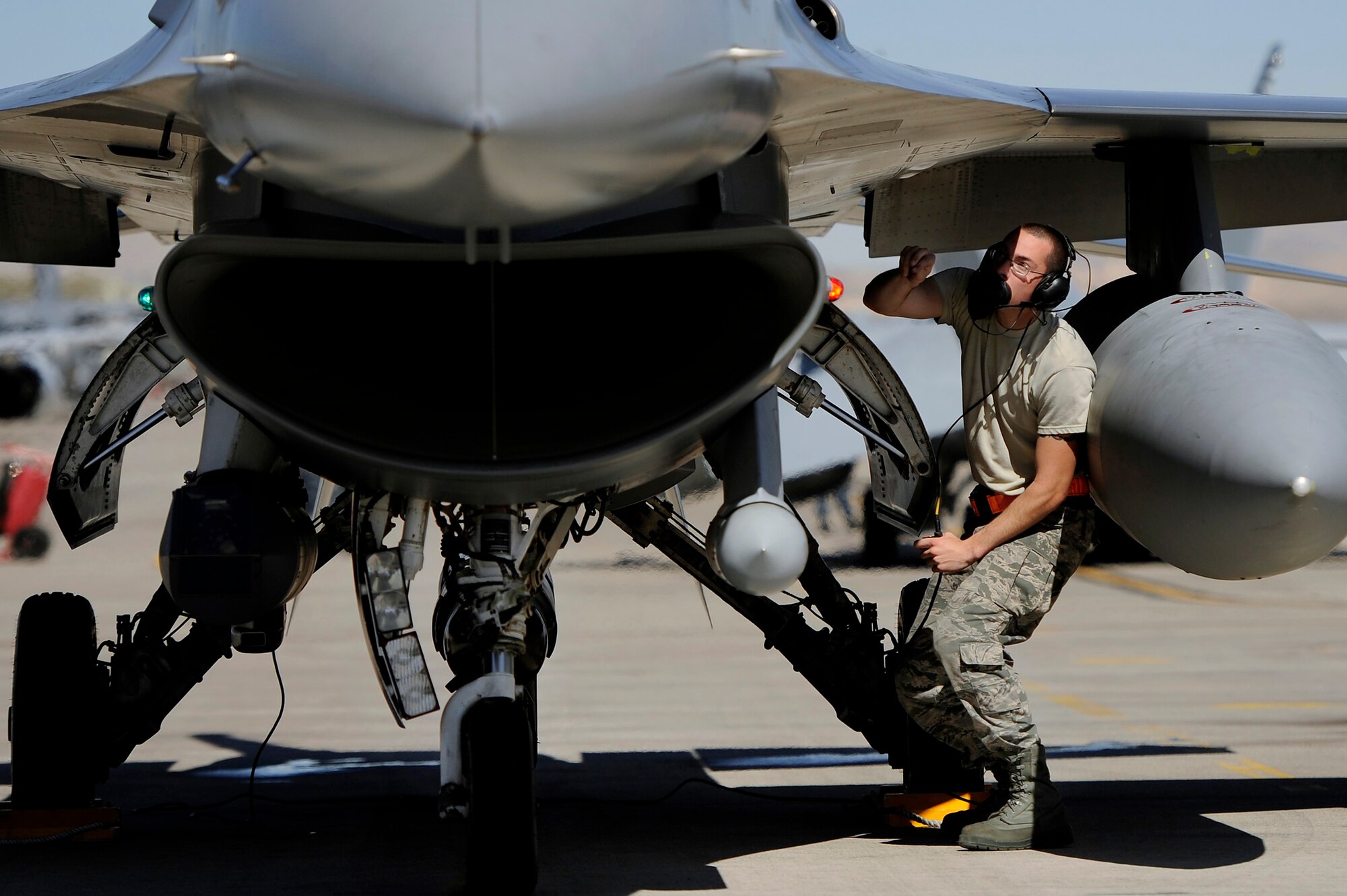 A U.S. Air Force crew chief assigned to the 20th Aircraft Maintenance Squadron performs preflight checks on a 79th Fighter Squadron ‘Tigers’ F-16 Fighting Falcon prior to takeoff during Red Flag 13-3, March 11, 2013, Nellis Air Force Base, Nev. About 23 crew chiefs from Shaw are participating in the Red Flag exercise. They have worked around-the-clock maintaining 79th FS jets so the pilots of the squadron are able to fly and get the training they need during each day of the exercise. (U.S. Air Force photo by Staff Sgt. Kenny Holston/Released)  