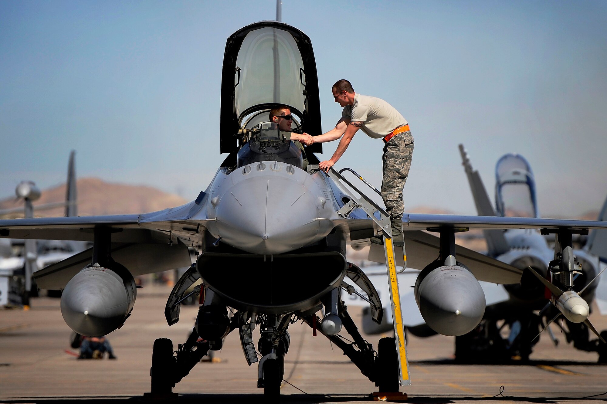 A U.S. Air Force crew chief assigned to the 20th Aircraft Maintenance Squadron shakes the hand of a 79th Fighter Squadron ‘Tigers’ pilot after prepping the pilots jet for a mission during Red Flag 13-3, March 11, 2013, Nellis Air Force Base, Nev. About 23 crew chiefs from Shaw are participating in the Red Flag exercise. They have worked around-the-clock maintaining 79th FS jets so the pilots of the squadron are able to fly and get the training they need during each day of the exercise. (U.S. Air Force photo by Staff Sgt. Kenny Holston/Released) 