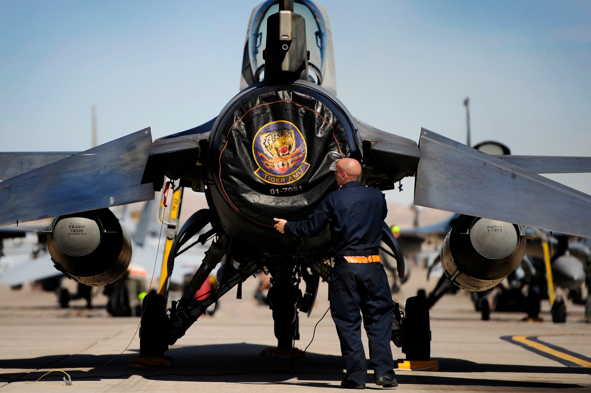 U.S. Air Force Senior Airman Cecil Lovette, 20th Aircraft Maintenance Squadron crew chief, takes the engine cover off of a 79th Fighter Squadron ‘Tigers’ F-16 Fighting Falcon prior to prepping the jet for a mission, March 11, 2013, Nellis Air Force Base, Nev. About 23 crew chiefs from Shaw are participating in the Red Flag exercise. They have worked around-the-clock maintaining 79th FS jets so the pilots of the squadron are able to fly and get the training they need during each day of the exercise. (U.S. Air Force photo by Staff Sgt. Kenny Holston/Released) 