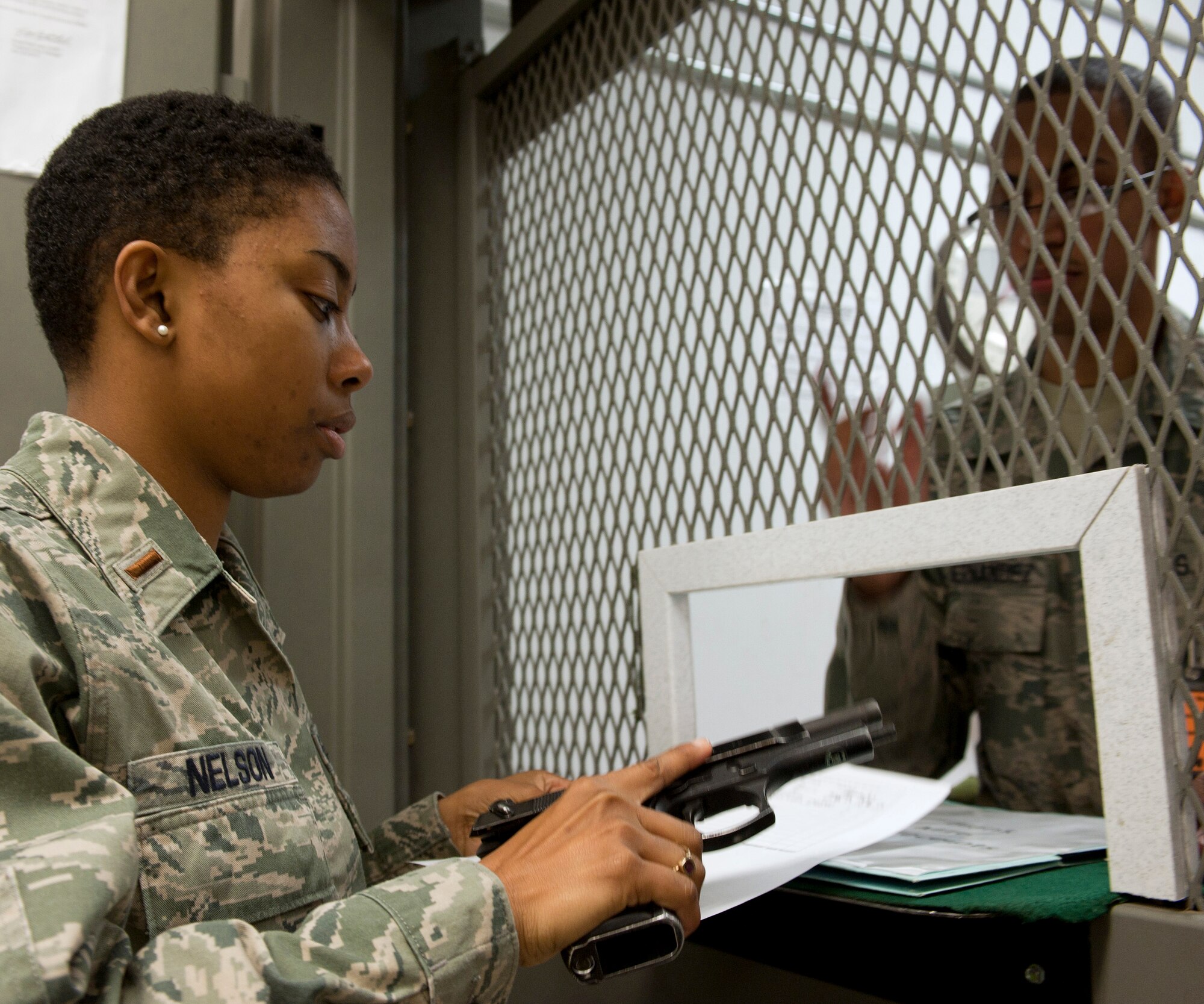 2nd Lt. Remoshay Nelson, 436th Airlift Wing Public Affairs, is issued an M-9 pistol by Airman 1st Class Josh Hernandez, 436th Logistics Readiness Squadron, Mar. 2, 2013, at Dover Air Force Base, Del. Nelson participated in the Operational Readiness Exercise which ran Mar. 2-8. (U.S. Air Force photo/Master Sgt. Jeanette Spain)