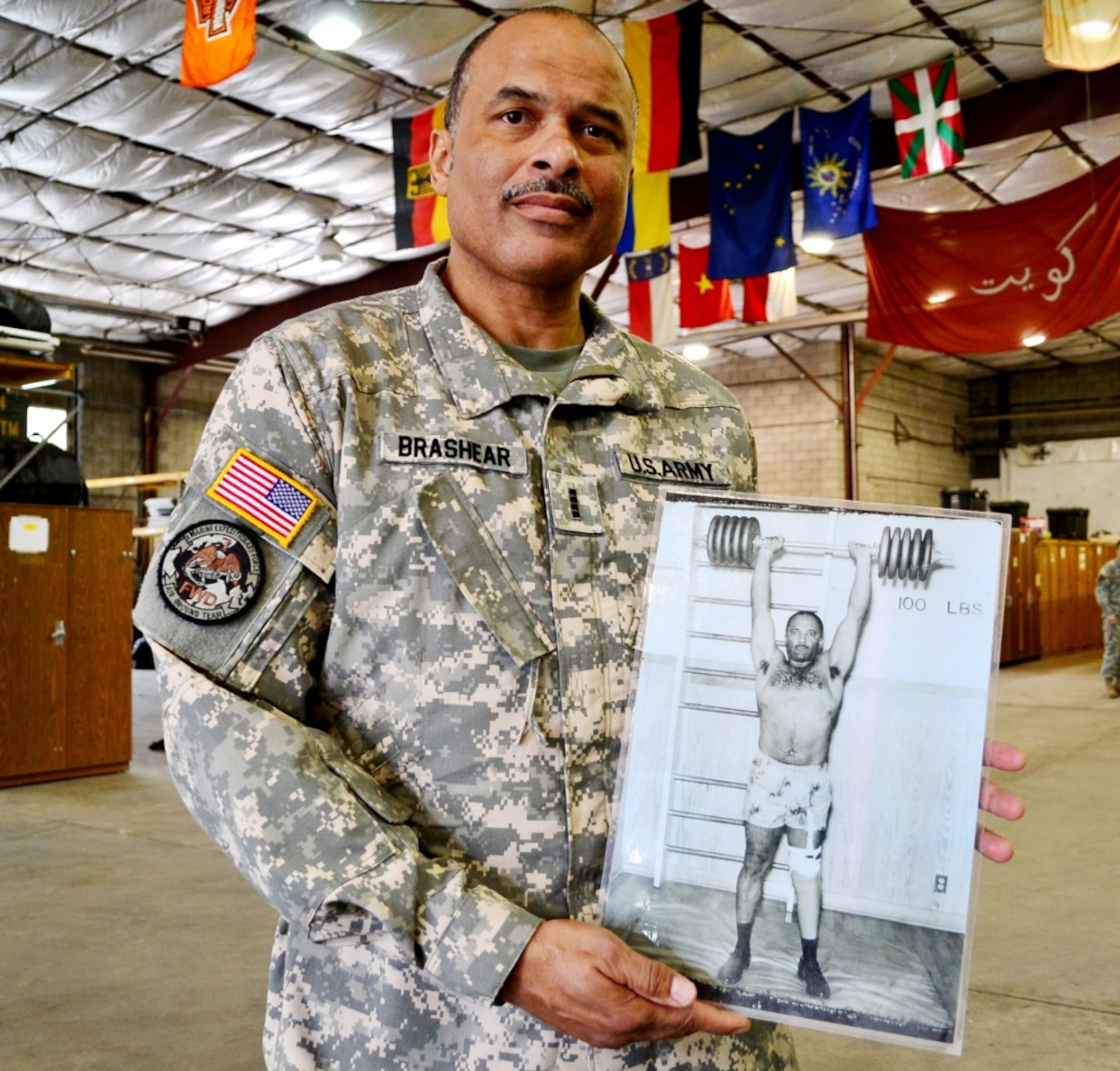 U.S. Army Chief Warrant Officer 4 Phillip Brashear, an Army Reserve CH-47 Chinook pilot with the 5th Battalion, 159th Aviation Regiment, holds a photograph of his late father, Carl Brashear, during a visit to the 511th Dive Detachment at Fort Eustis, Va., March 1, 2013. Carl Brashear was the first African-American to become a U.S. Navy master diver, and retired from the Navy as a master chief petty officer. While visiting the detachment, Phillip told current Army divers about his father's triumphs and success in the face of adversity, and thanked them for continuing the legacy of military divers. (U.S. Army photo by Sgt. Edwin J. Rodriguez/Released)