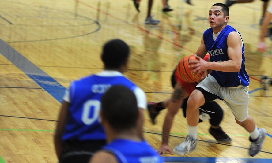 Airman 1st Class Richard Gere, 28th Civil Engineer Squadron electrical systems technician, crosses a defender during the base 2013 Intramural Basketball League tournament in the Bellamy Fitness Center at Ellsworth Air Force Base, S.D., Feb. 21, 2013. Games are scheduled Monday through Friday from 5 to 8 p.m., and will continue until March 16. (U.S. Air Force photo by Airman 1st Class Hrair H. Palyan/Released)