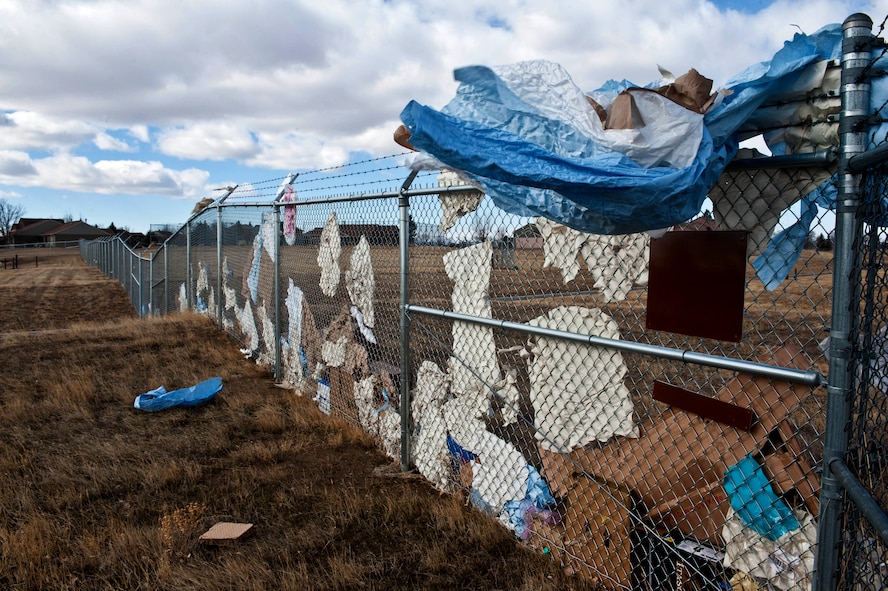 Due to frequent high winds, trash often accumulates along the fence line at Ellsworth Air Force Base, S.D., March 4, 2013.  Housing residents, can prevent accumulation of loose trash around the base by securing the lids with a bungee cord. (U.S. Air Force photo by Airman 1st Class Zachary Hada/Released)