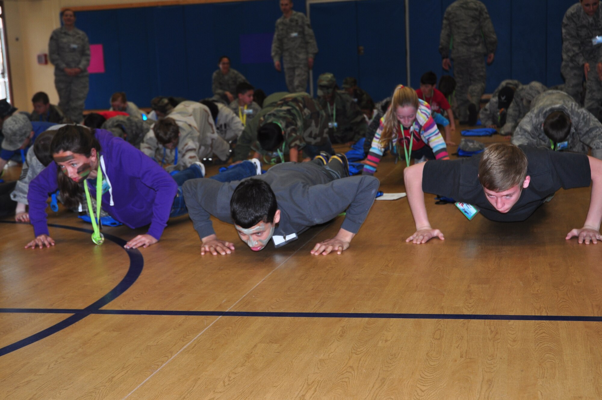Team Tyndall dependents practice their push ups during Operation Jr. Raptor March 9. The event gives miltary children the chance to experience first hand what a deployment is like. (U.S. Air Force photo by 2nd Lt. Andrea Valencia)