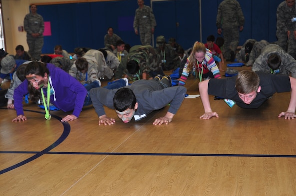 Team Tyndall dependents practice their push ups during Operation Jr. Raptor March 9. The event gives miltary children the chance to experience first hand what a deployment is like. (U.S. Air Force photo by 2nd Lt. Andrea Valencia)