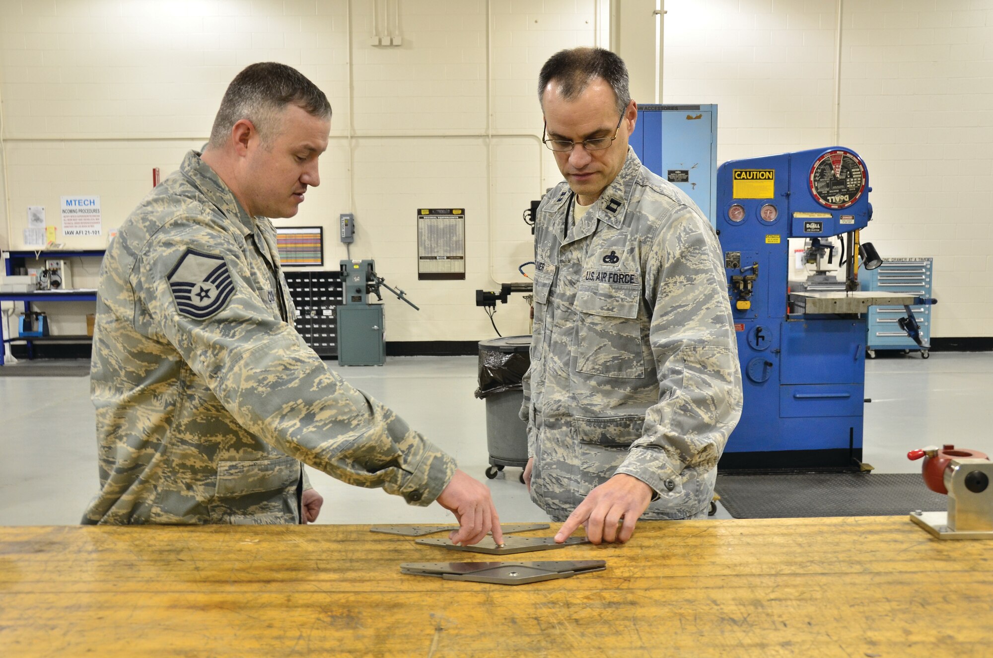 WRIGHT-PATTERSON AIR FORCE BASE, Ohio - Master Sgt. Jason Cox shows Capt. Terrell Eikner, both from the 445th Maintenance Squadron, a flap bracket repair piece. Both reservists were awarded the AFRC 2012 Lieutenant General Leo Marquez Award in their respective categories. (U.S. Air Force photo/Stacy Vaughn) 