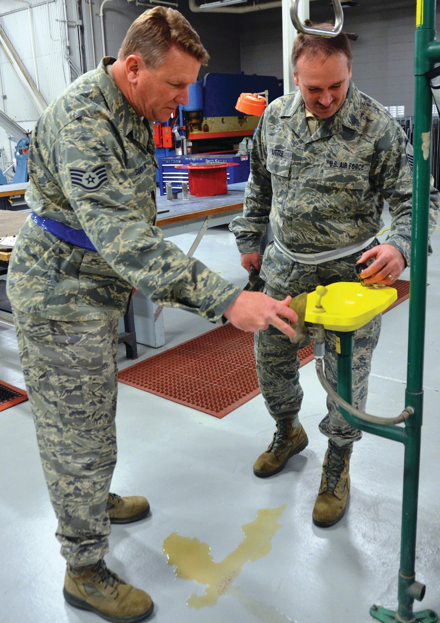 WRIGHT-PATTERSON AIR FORCE BASE, Ohio - Staff Sgt. Steven Sandman and Master Sgt. Richard Little, both ground safety specialists from the 445th Airlift Wing Safety office, test an eye wash station in building 4024 after flushing the corroded water out that stemmed from a water main break. (U.S. Air Force photo/Senior Airman Matthew Cook)