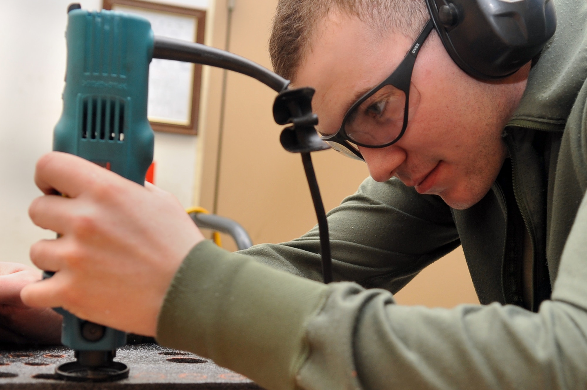 Senior Airman Garrett Loucks, 51st Logistics Readiness Squadron vehicle managment technician, carves tool box foam for an individual tool kit upgrade at the VM main shop at Osan Air Base, Republic of Korea, March 12, 2013. A team of VM Airmen are reorganizing 21 tool boxes as part of the project. (U.S. Air Force photo/Senior Airman Alexis Siekert)
