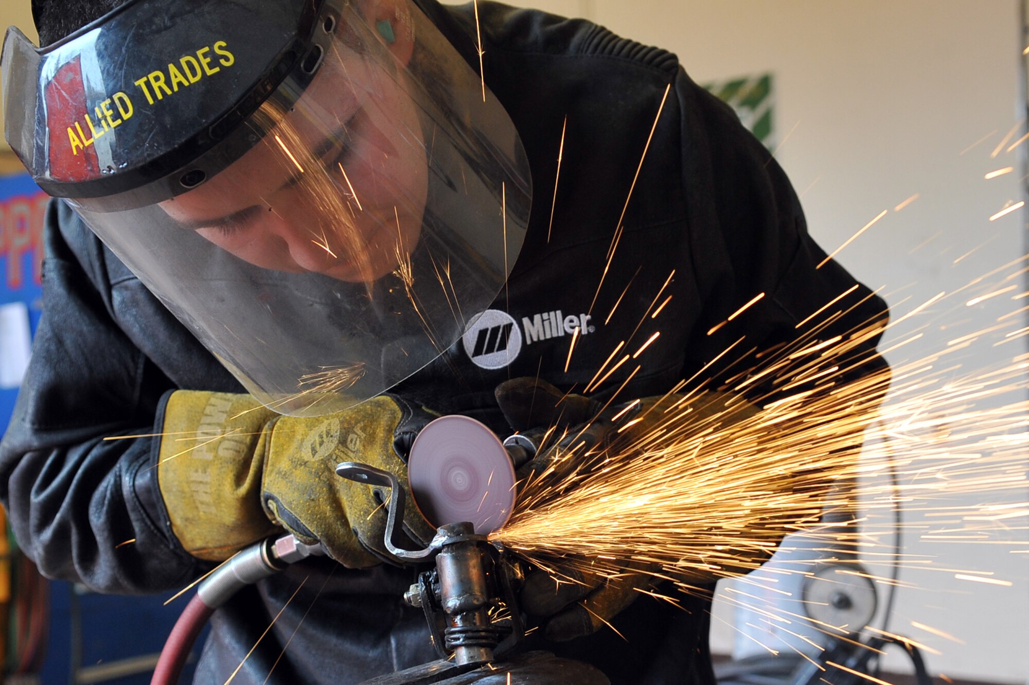 Senior Airman Shiras Dara, 51st Logistics Readiness Squadron vehicle managment technician, grinds a part after welding it in the allied trades shop at Osan Air Base, Republic of Korea, March 12, 2013. The allied trades shop, better known as the body shop, is a specialized facility to include metal work and painting. (U.S. Air Force photo/Senior Airman Alexis Siekert)
