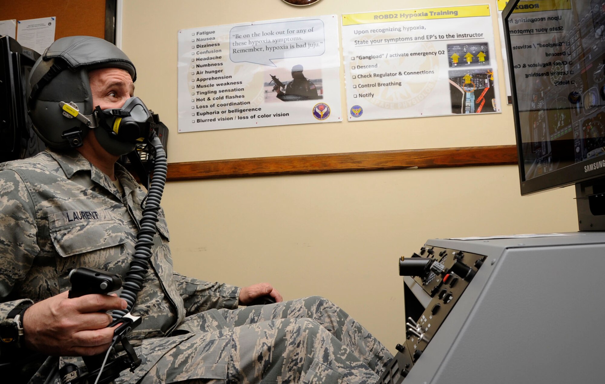 U.S. Air Force Chief Master Sgt. James Laurent, 35th Fighter Wing command chief, simulates flying in a new hypoxia familiarization trainer in the 35th Operations Group building at Misawa Air Base, Japan, March 12, 2013. To combat hypoxia, pilots must recognize their individual symptoms and experience a hypoxic state. Symptoms of hypoxia include headaches, fatigue, shortness of breath and a feeling of nausea or euphoria. (U.S. Air Force photo by Airman 1st Class Kenna Jackson)
