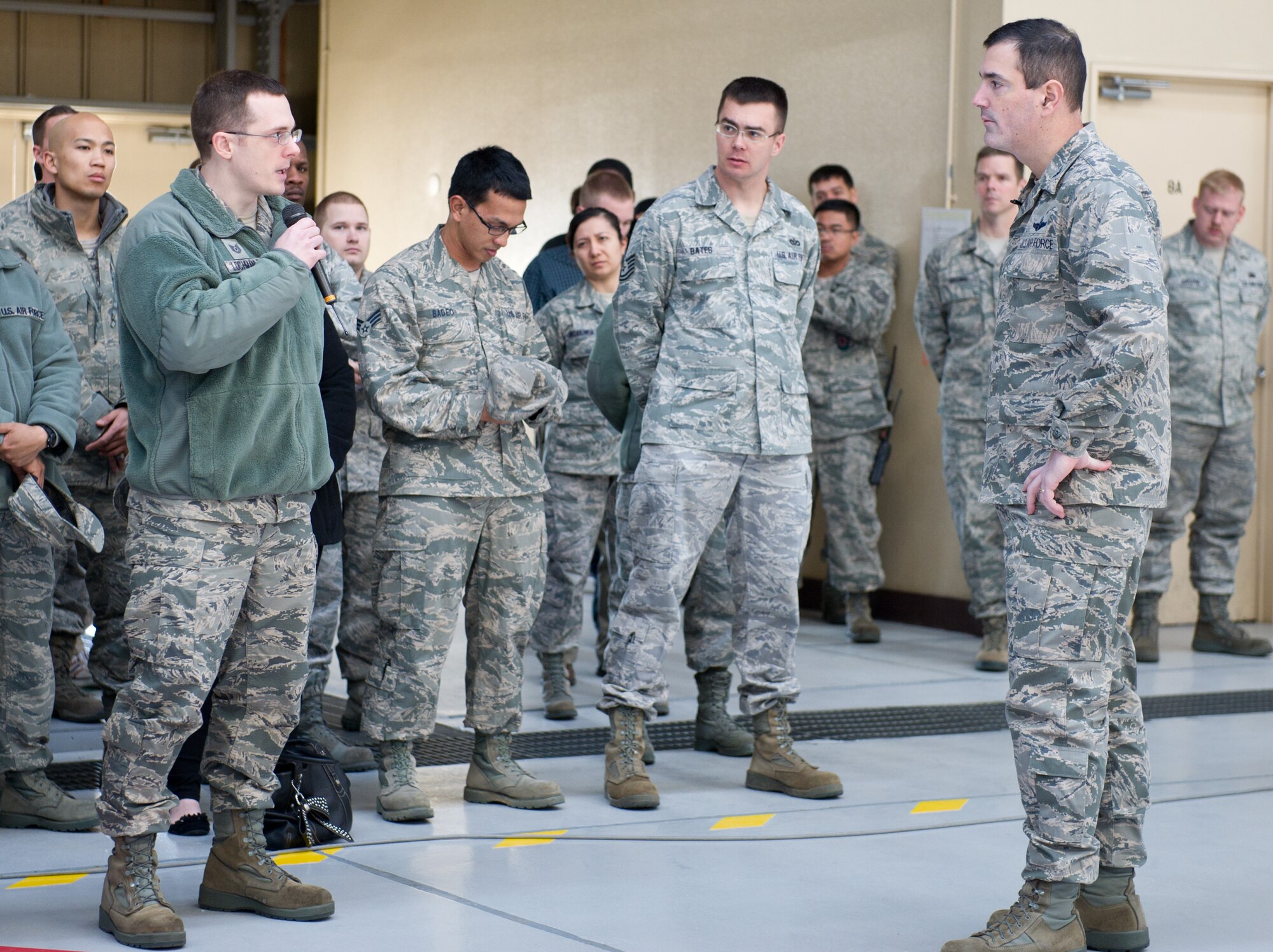 YOKOTA AIR BASE, Japan -- Tech. Sgt. Clayton Lochman, 374th Maintenance Squadron, left, asks a question concerning Yokota's response to financial challenges stemming from sequestration to Col. Mark August, 374th Airlift Wing commander, right, during a commander's call at Yokota Air Base, Japan, March 12, 2013. August urged Airmen to protect, preserve and consume government resources as if they were their own. He also stressed that Yokota will maintain its core capabilities, even as leaders seek to do less with less. (U.S. Air Force photo by Senior Airman Andrea Salazar)