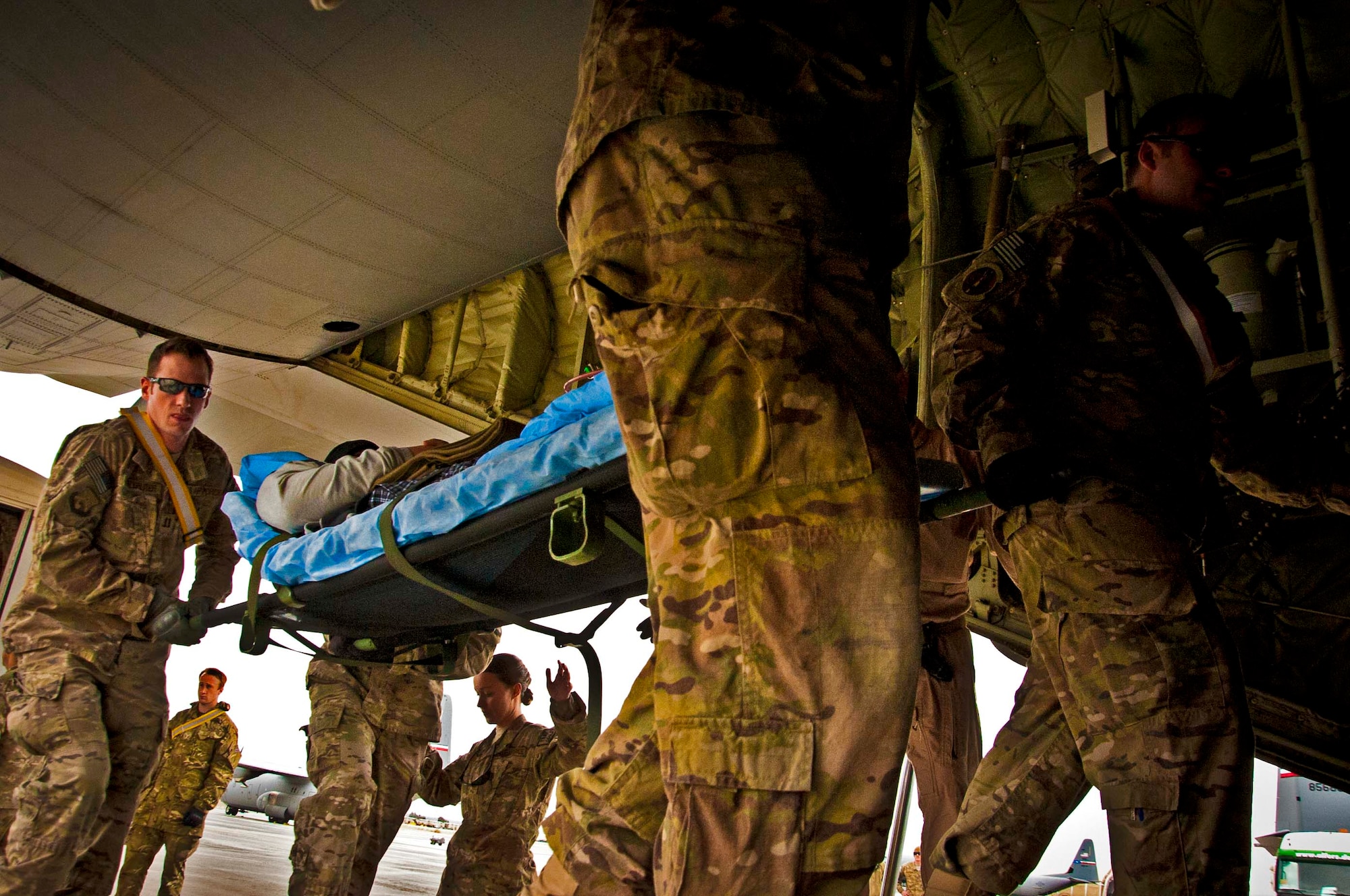 Volunteers and 651st Expeditionary Aeromedical Evacuation Squadron Contingency Aeromedical Staging Facility personnel carry a litter patient into a C-130J aircraft at Kandahar Airfield, Afghanistan, Feb. 21, 2013. The CASF acts as a liaison between flights coming in and the hospital. They also sustain care for patients until their departure. (U.S. Air Force photo/Senior Airman Scott Saldukas)   