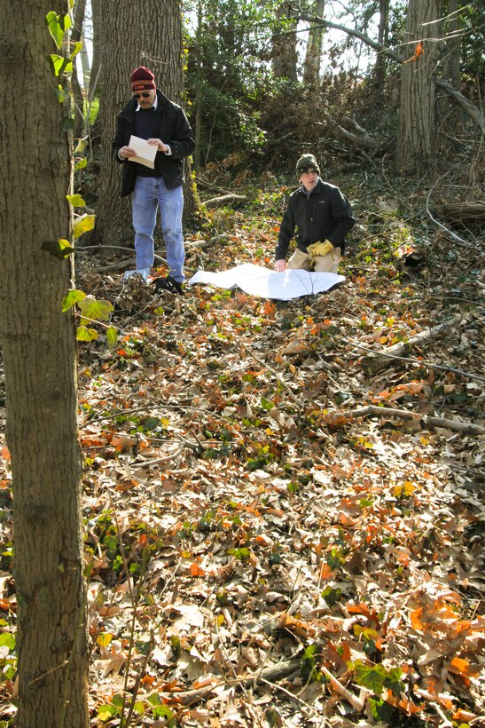 ARLINGTON; Va. -- Paul Carter (left), a Norfolk District forester; and Stephen Van Hoven, Arlington National Cemetery’s Horticulture Division chief, reference detailed drawings and markings to determine their exact location within the Arlington National Cemetery Millennium Project here, Feb. 6, 2013. The two men investigating the age of trees located within the project boundaries to ensure the initial estimates on tree ages documented in the project’s environmental assessment are correct. The Millennium Project will add 27 acres to the cemetery and nearly 30,000 additional burial and niche spaces. (U.S. Army photo/Patrick Bloodgood)