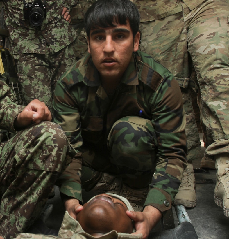 Medics with the Afghan National Army practice treating injuries and loading injured personnel into medical helicopters aboard Camp Bastion, Afghanistan March 12. The ANA medics worked alongside U.S. and British medical personnel to practice litter carrying patients aboard a Royal Merlin helicopter. (U.S. Marine Corps photo by Sgt. Bryan A. Peterson)
