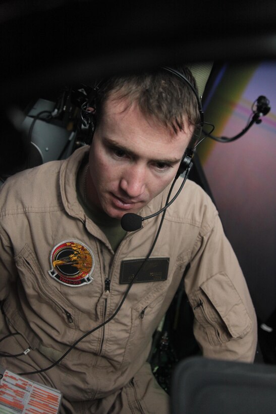 1st Lt. Matthew C. Forman, a replacement pilot with Marine Attack Training Squadron 203, looks over notes during his preflight checks flight in an AV-8B Harrier simulator March 11. After two weeks in a classroom setting, the students began utilizing the simulator to progress their skills.
