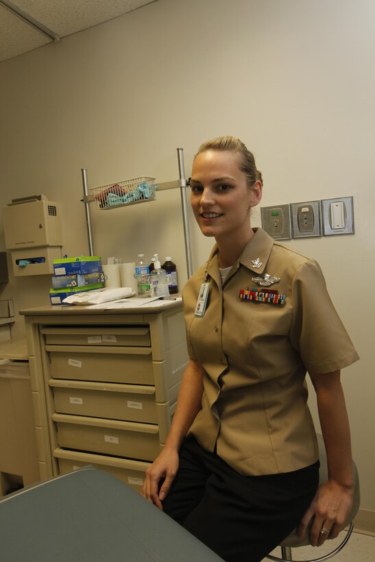 Petty Officer 2nd Class Christina Koch sits in an examing room aboard  Naval Health Clinic Cherry Point