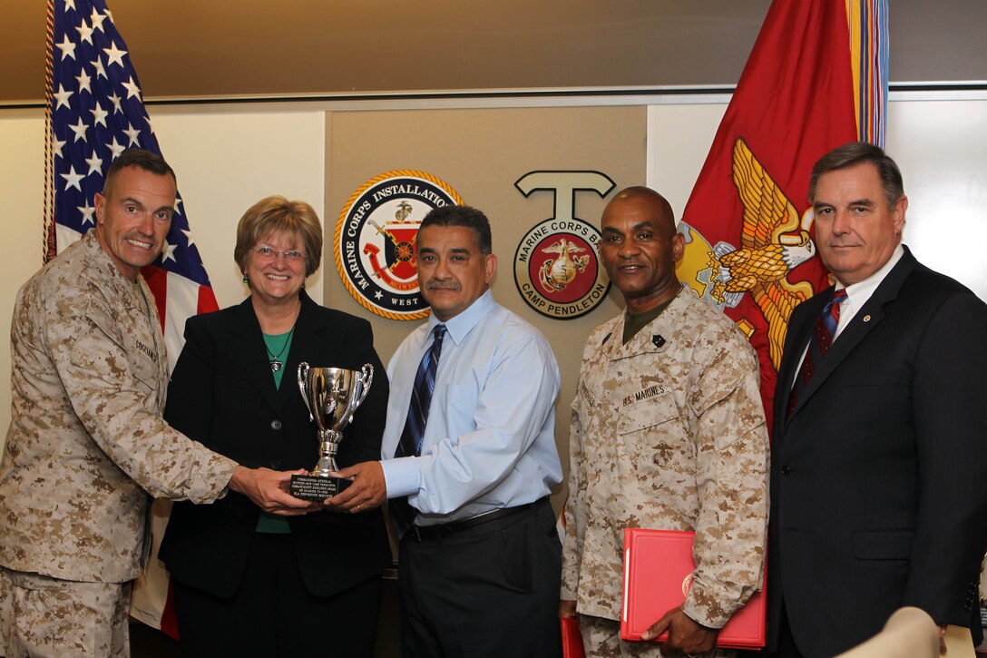 Carry Groves and Juan Garcia received the Command Safety Excellence Award on behalf of the Defense Logistics Agency Disposition Services during a ceremony held by Brig. Gen. Vincent A. Coglianese, left, and Sgt. Maj. Derrick Christovale Sr., center-right, in the commanding general’s conference room March 12.