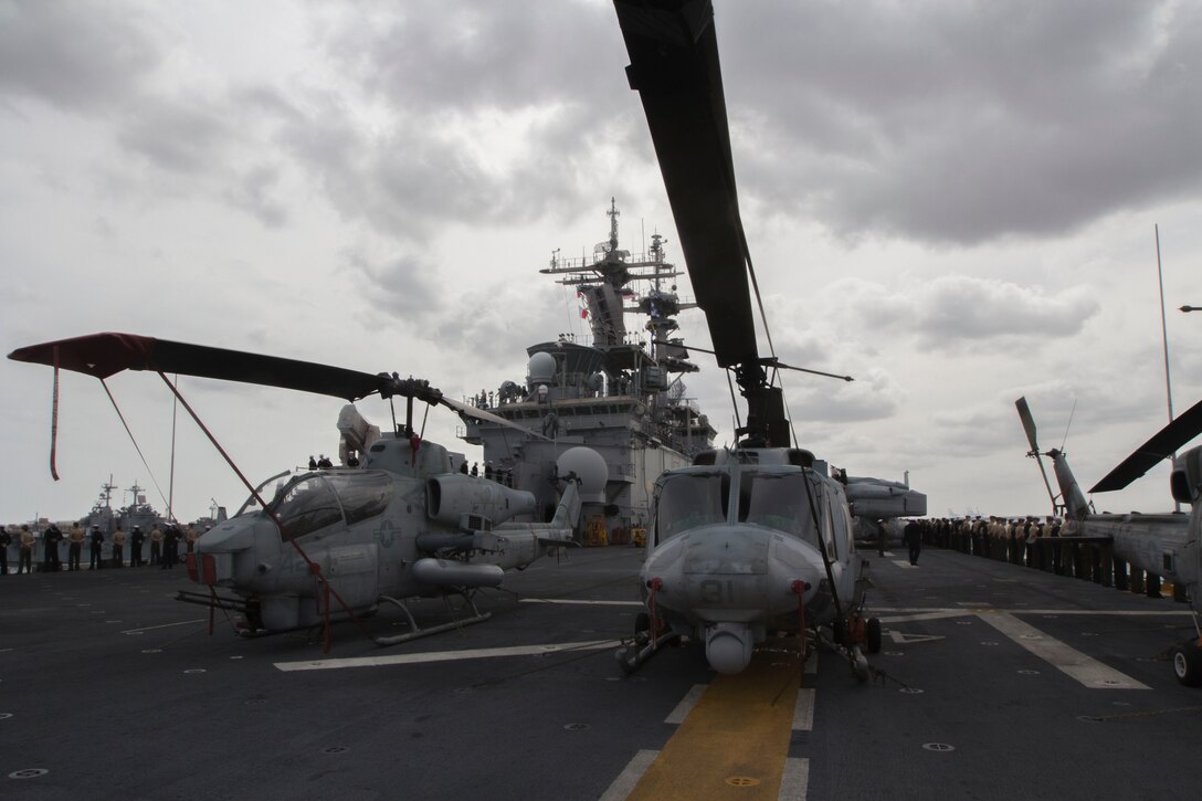 Marines and Sailors assigned to the 26th Marine Expeditionary Unit, and Sailors assigned to the USS Kearsarge (LHD 3), man the rails while departing Naval Station Norfolk, Va., to embark on their deployment March 11, 2013. The 26th MEU is deploying to the 5th Fleet and 6th Fleet areas of operation. The MEU operates continuously across the globe, providing the president and unified combatant commanders witha  a forward-deployed, sea-based, quick-reaction force. The MEU is a Marine Air-Ground Task Force capable of conducting amphibious operations, crisis-response and limited contigency operations. (U.S. Marine Corps photo by Cpl. Kyle N. Runnels/Released)