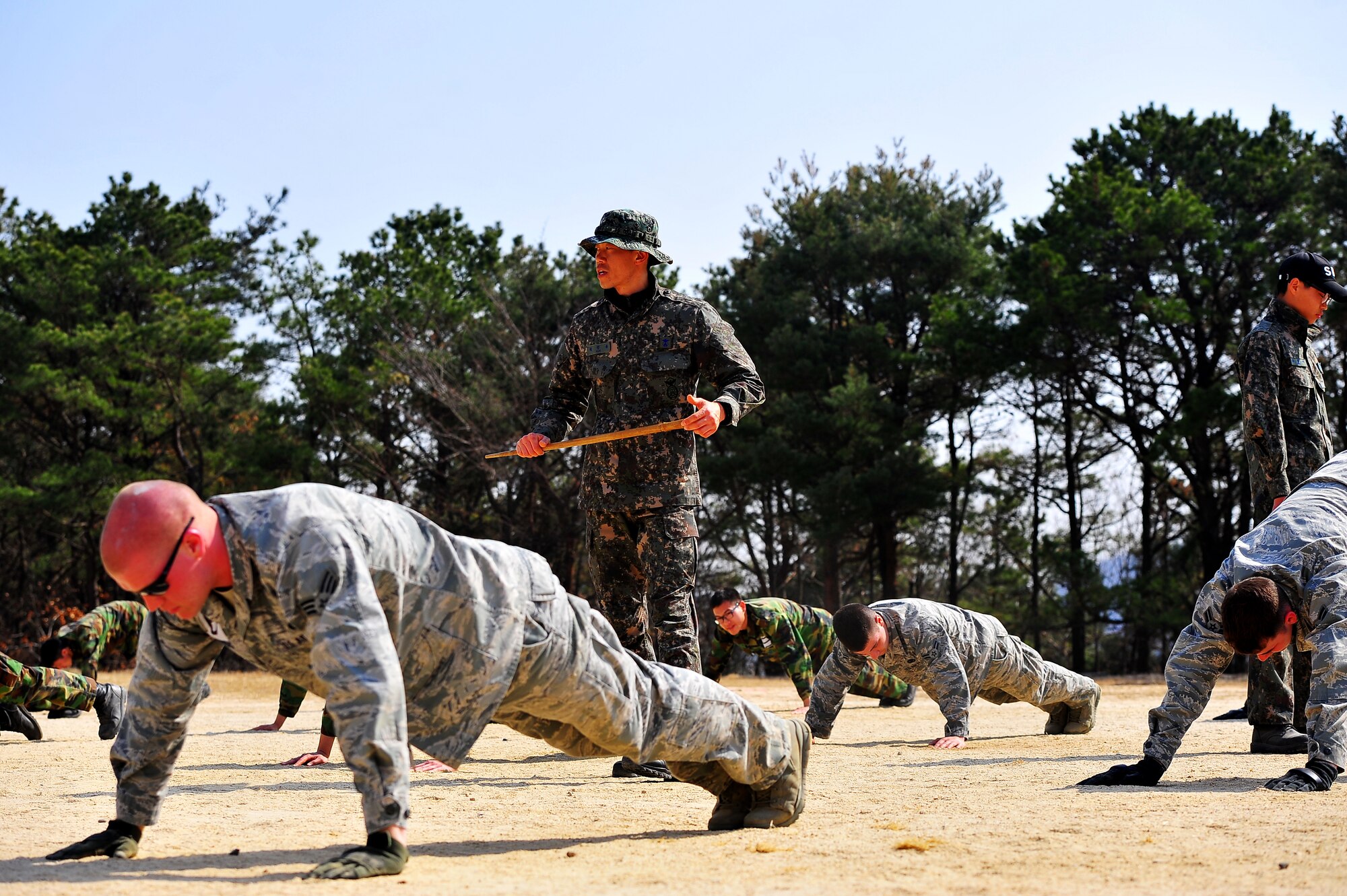 A Republic of Korea Air Force military police instructor watches over trainees during a physical training session at the Jinjui Air Force Education and Training Command Republic of Korea, March 6, 2013.  This was the first time Osan Airmen participate in an air police special duty team course in all most 30 years. (U.S. Air Force photo/Staff Sgt. Emerson Nuñez)
