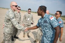 U.S. Air Force Senior Airman Corey Henry, an F-15C armament technician, greets a Republic of Singapore Airman before an F-15 aircraft maintenance exchange between U.S. and RSAF aircraft maintainers during Cope Tiger 13 at Korat Royal Thai Air Force Base, Thailand, March 12, 2013. Henry is assigned to the 44th Aircraft Maintenance Unit at Kadena Air Base, Japan. More than 300 U.S. service members are participating in CT13, which offers an unparalleled opportunity to conduct a wide spectrum of large force employment air operations and strengthen military-to-military ties with two key partner nations, Thailand and Singapore. (U.S. Air Force photo/2nd Lt. Jake Bailey)