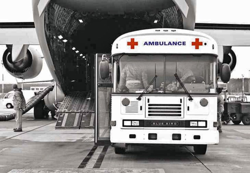 An ambulance bus backs up to a C-17 Globemaster III to receive incoming wounded patients. Timing is crucial, especially for critically injured patients, so doctors, nurses, medics, chaplains and liaison officers have limited time to offload patients and get them much needed treatment. (U.S. Air Force courtesy photo)