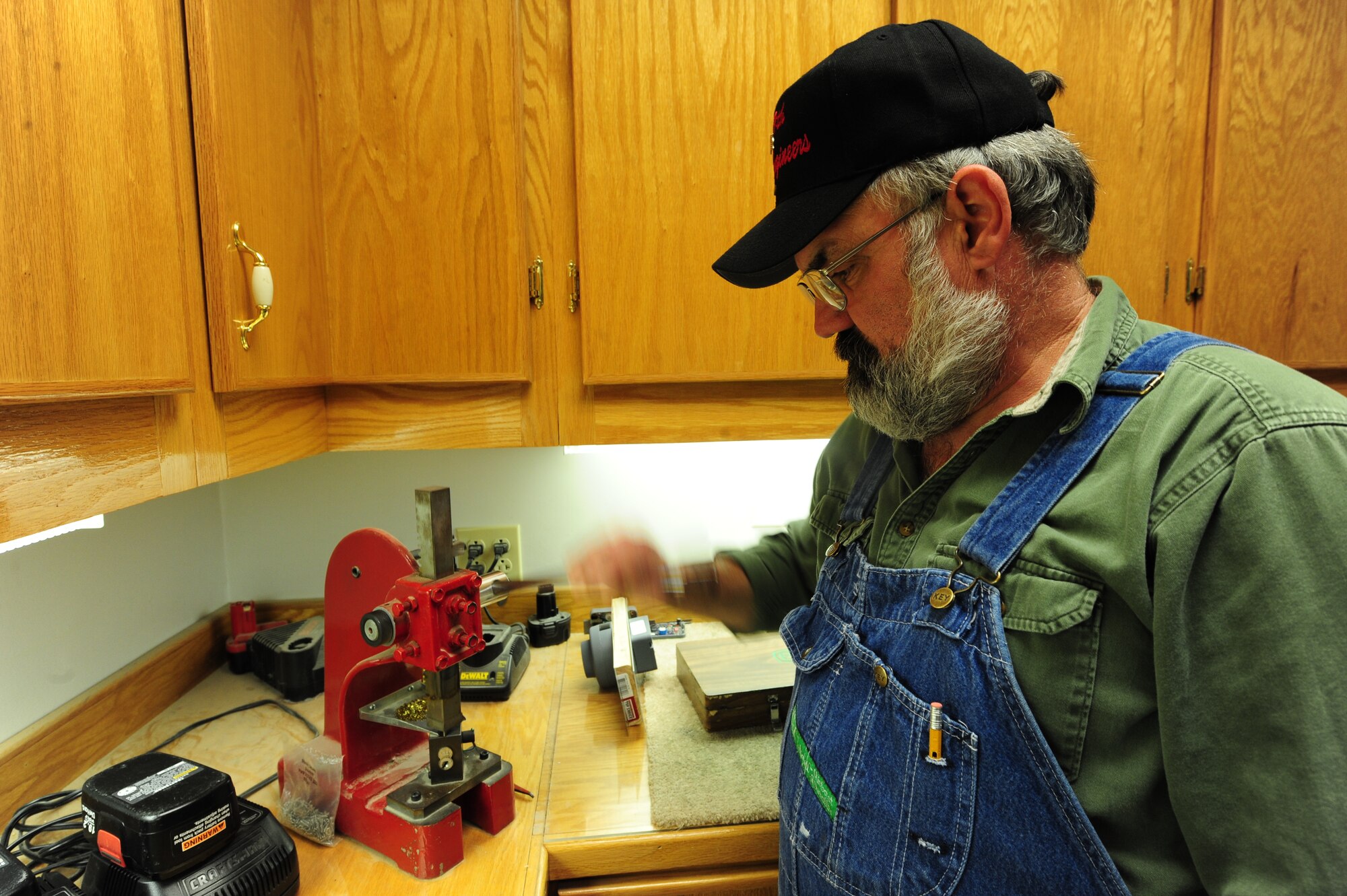 WHITEMAN AIR FORCE BASE, Mo. -- Jack Crain, 509th Civil Engineer Squadron locksmith, presses caps into the core of a lock, March 6. The caps seal the chamber of the lock, keeping critical components hidden so the lock cannot be picked. (U.S. Air Force photo/Staff Sgt. Nick Wilson) (Released)