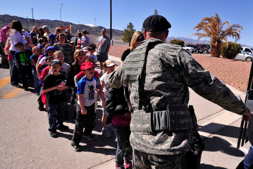 LAS VEGAS, Nev. – A security forces Airman welcomes school children from Indian Springs Elementary School during Indian Springs Appreciation Day, March 12. Students and members of the local community attended the event, which takes place annually, to learn about various Air Force missions. (U.S. Air Force photo by Staff Sgt. A.D./Released) 