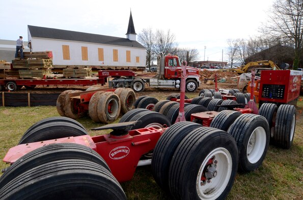 The driving and steering trucks which will be used to transport the Dobbins chapel sit on-site as personnel from Hercules House Movers work to remove dirt and prep the ground for the installation of the trucks under the chapel, Mar 4.  The Dobbins chapel will be moved to the Army National Guard side of the base on Mar. 17.  (U.S. Air Force photo/Brad Fallin)