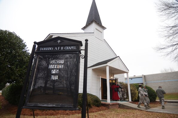 Personnel pass through the familiar double doors departing after attending the final service held at the Dobbins Air Reserve Base Chapel, Jan. 6. The Chapel, a familiar site to personnel who work on or pass through the front gate will soon see an empty space as the structure is slated to be moved. (U.S. Air Force photo/Don Peek)