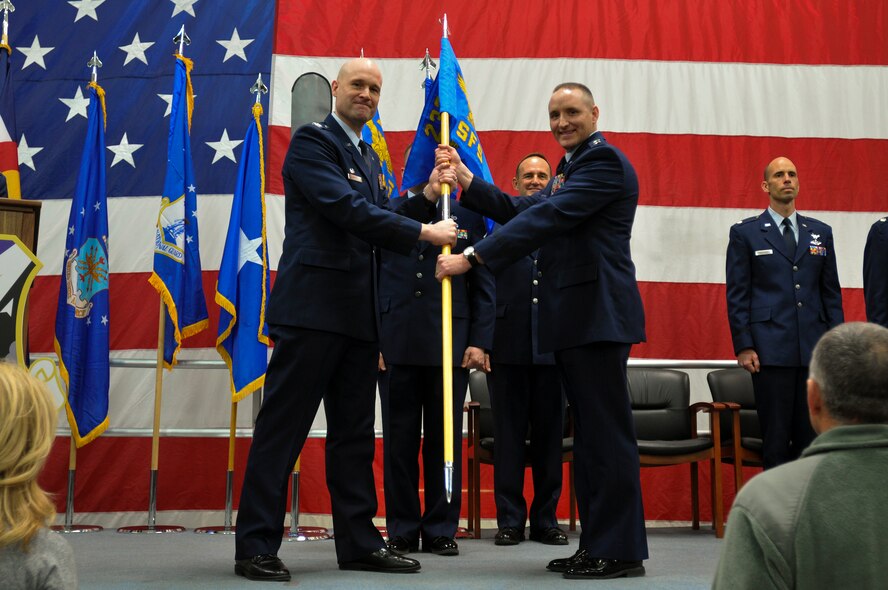 Air National Guard Col. Gregory T. White, 233d Space Group Commander, hands the 233d Security Forces Squadron flag to Capt. K. Aaron Kemplin, the newly appointed 233d Security Forces Squadron Commander, during the 233d Space Group Activation Ceremony, March 10, 2013, Greeley Air National Guard Station, Greeley, Colo.   The 137th Space Warning Squadron reorganized as the 233d Space Group and will continue to operate under the 140th Wing, performing the one-of-a-kind Mobile Ground System mission that these men and women have been doing since 1996. (Air National Guard photo by Tech. Sgt. Wolfram M. Stumpf)