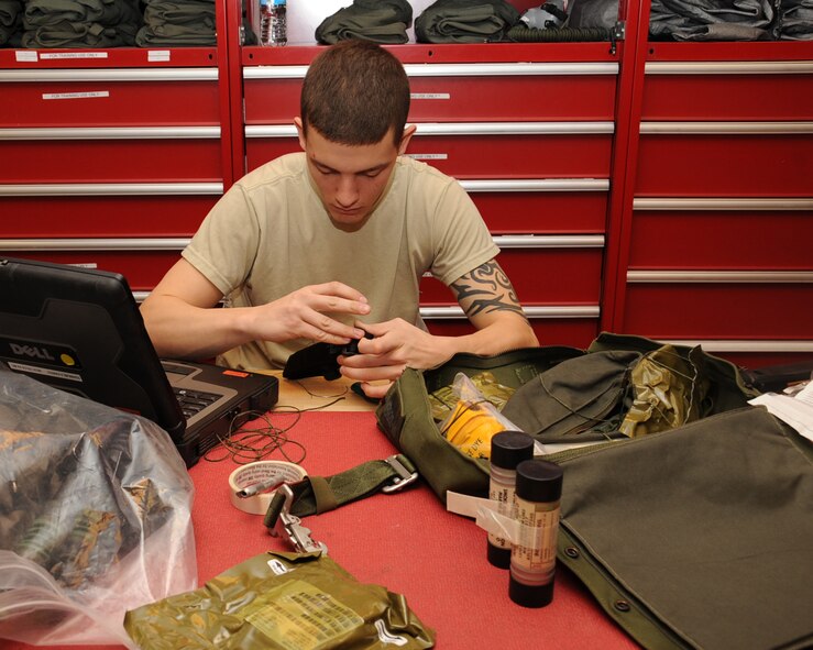 Airman 1st Class Michael Fields, 2nd Operation Support Squadron Aircrew Flight Equipment, works on a soft survival kit on Barksdale Air Force Base, La., March 13. The soft kit includes life-saving equipment in the event of an egress to include flares, sea dye, a strobe light, tourniquet, knife and candle. (U.S. Air Force photo/Senior Airman Sean Martin)
