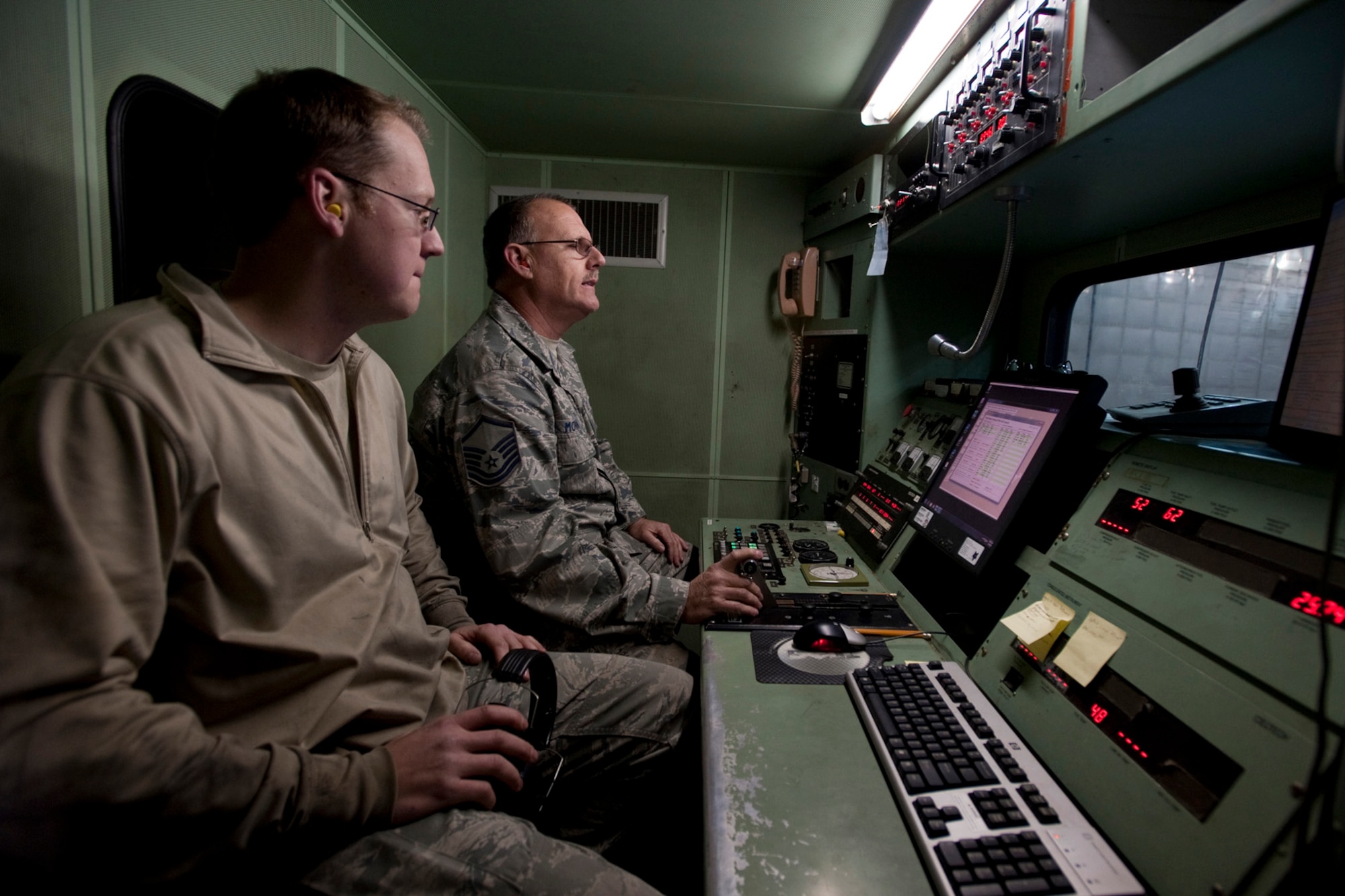 U.S. Air Force Airman 1st Class Jonathan Salvador watches as Master Sgt. Rick Morgan, a mechanic with the 169th Maintenance Squadron propulsion unit at McEntire Joint National Guard Base, S.C., controls the block 52 jet engine and observes instrument readings from inside the T-20 test cab at the hush house, March 2, 2013. Salvador and Morgan are inspecting the engine for leaks in case the engine is faulty it will need a complete overhaul. The hush house allows jet engine mechanics to test F-16 engines without having extra noise pollution disturb base operations. (National Guard photo by Staff Sgt. Jorge Intriago/Released)