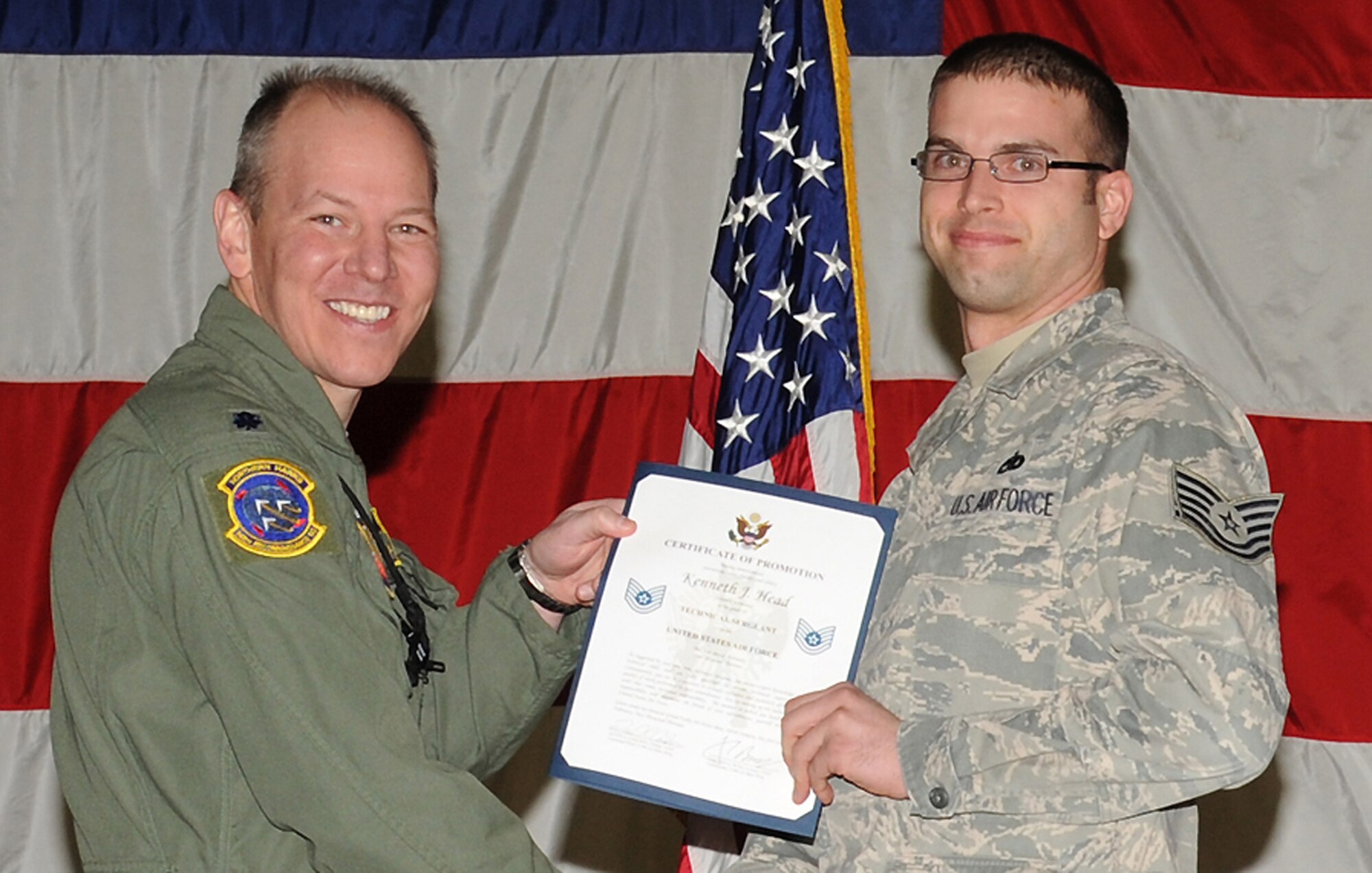 (From left) Lt. Col. Scott West, 348th Reconnaissance Squadron commander, presents Tech. Sgt. Kenneth Head with a certificate recognizing his promotion during a ceremony Jan. 31, 2013, on Grand Forks Air Force Base, N.D.  Head is Grand Forks AFB’s Warrior of the Week for second week of March 2013. (U.S. Air Force photo/Airman 1st Class Xavier Navarro) 