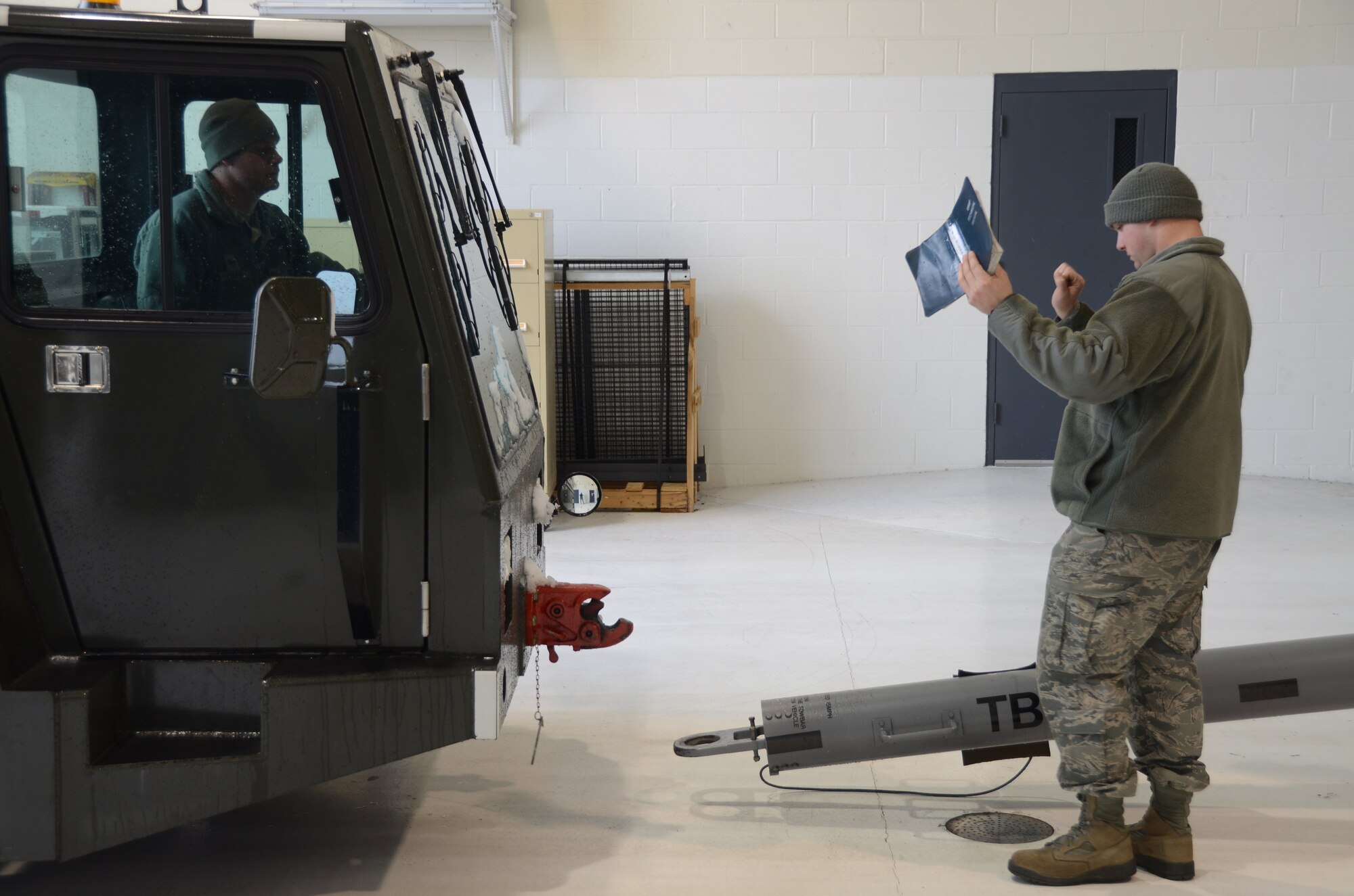 Staff Sgt. Kenneth Baque, a member the 126th Maintenance Group, guides Staff Sgt. Mark Trapp, a crew chief for the 906th Air Refueling Squadron, toward the pivot point for the aircraft tow vehicle in preparation to move a KC-135R Stratotanker on Scott Air Force Base, Ill., March 5, 2013. The aircraft was being positioned appropriately on the flightline to undergo a few scheduled and routine inspections.  The 906 ARS is an Active Associate squadron of the 126th Air Refueling Wing, Illinois Air National Guard, and is comprised of Active Duty Air Force members. (National Guard photo by Airman 1st Class Elise Stout)
