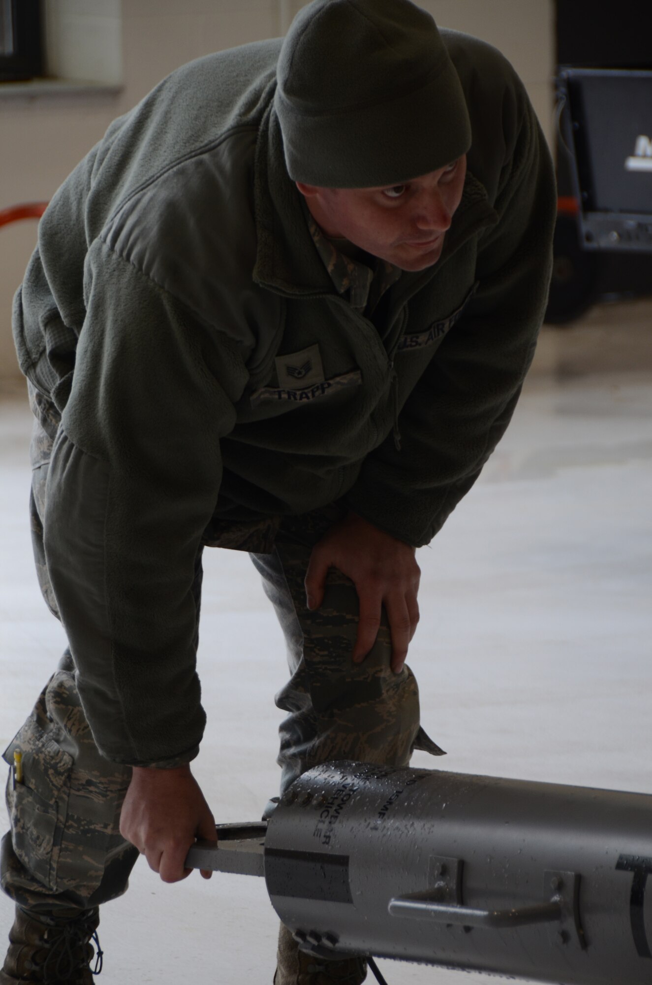 Staff Sgt. Mark Trapp, a crew chief for the 906th Air Refueling Squadron,helps to position a pivot point to move a KC-135R Stratotanker out of ahangar on Scott Air Force Base Ill., March 5, 2013. The aircraft was being returned to the flightline after a small snowfall that could have negatively impacted flights scheduled a few hours later that afternoon. The 906 ARS is an Active Associate squadron of the 126th Air Refueling Wing, Illinois Air National Guard, and is comprised of Active Duty Air Force members. (National Guard photo by Airman 1st Class Elise Stout)
