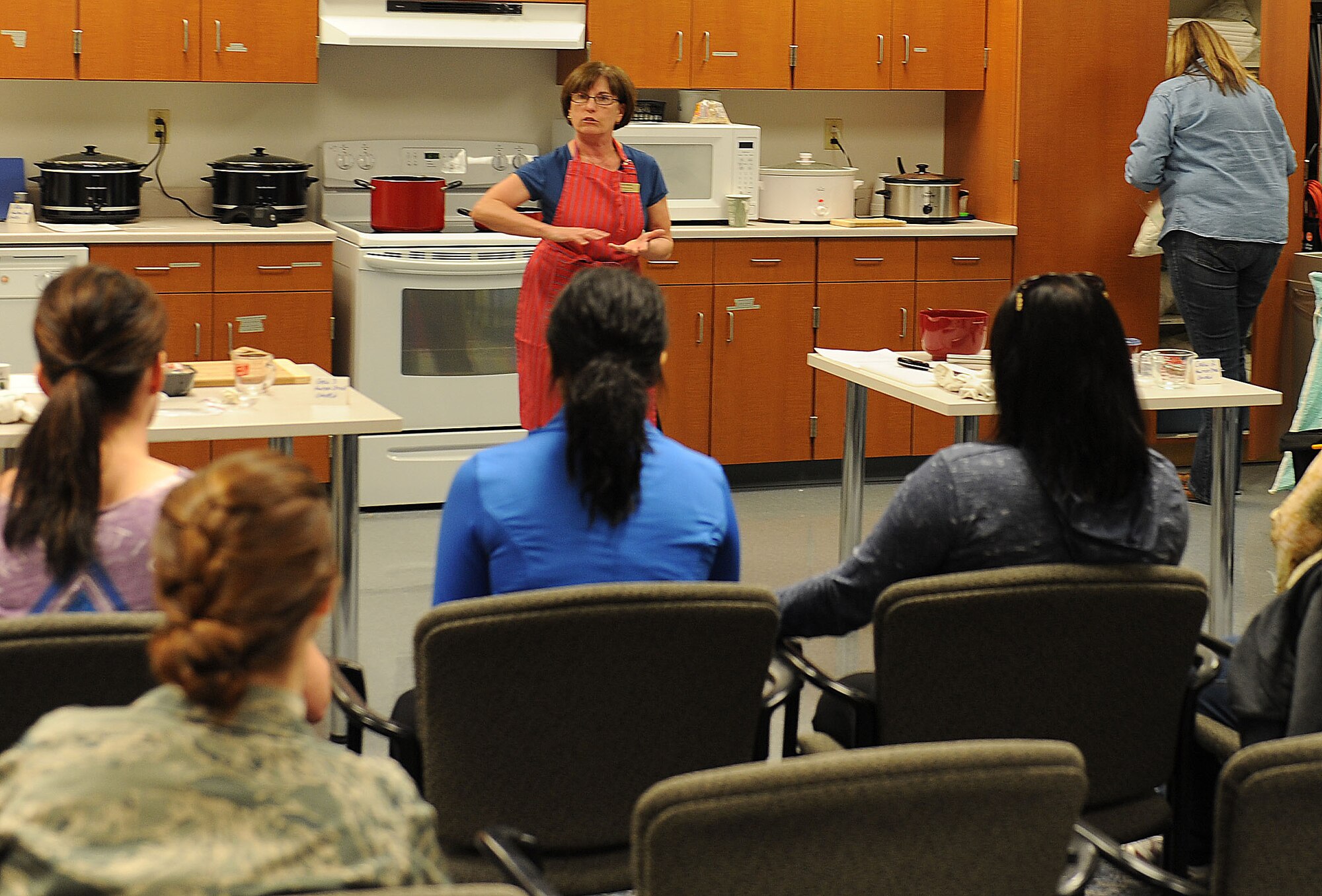 Kathy Steinbrecher, Health and Wellness Center health promotion dietitian, teaches a cooking class at the Airman and Family Readiness Center March 8.  The Foodie Friday cooking class showed participants how to use a slow cooker to prepare meals using budget-friendly cuts of meat and poultry.  The class learned three healthy recipes. (U.S. Air Force photo/Staff Sgt. Maria Bowman)
